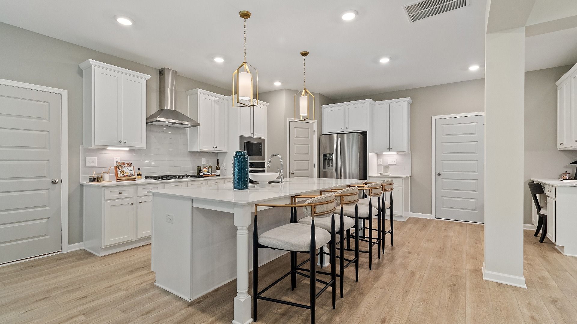 Modern kitchen with island seating, pendant lighting, and stainless appliances at Trinity Park in McDonough, GA.
