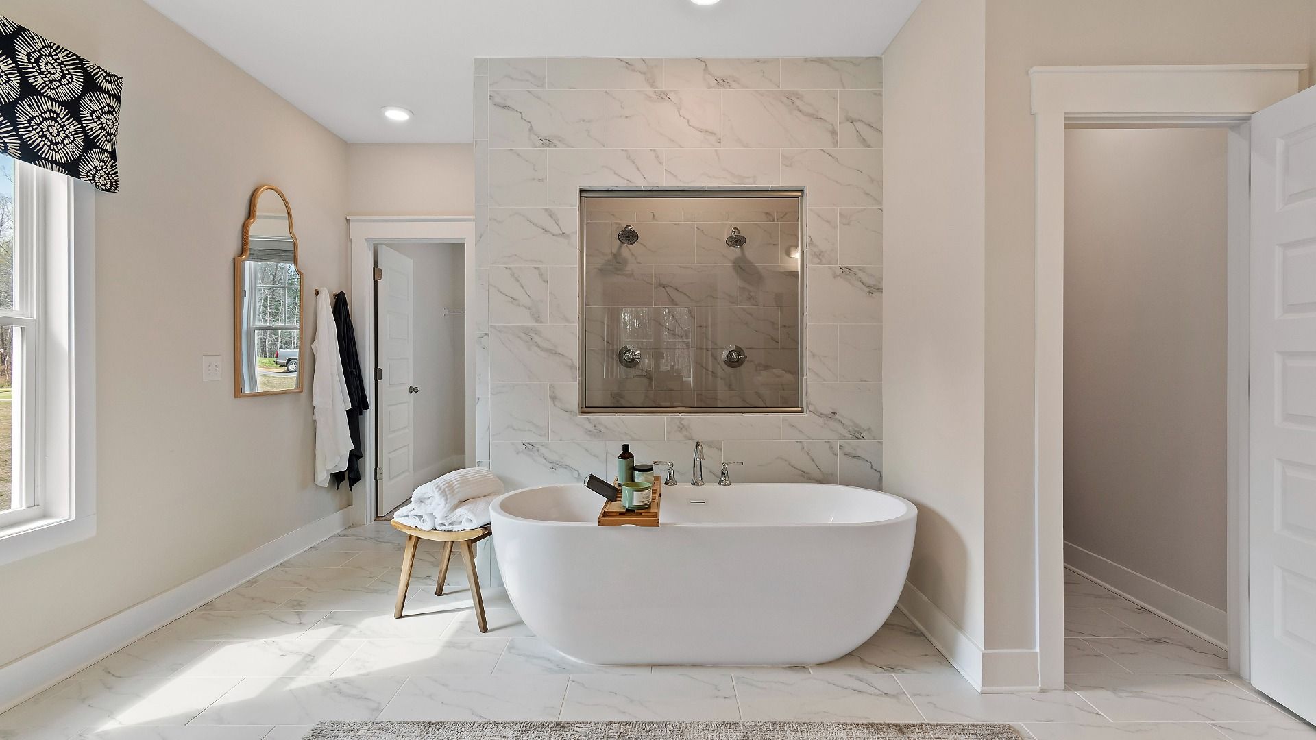 Primary bath with luxury tile flooring and wall, featuring a freestanding tub at Saddleridge in Senoia, GA.