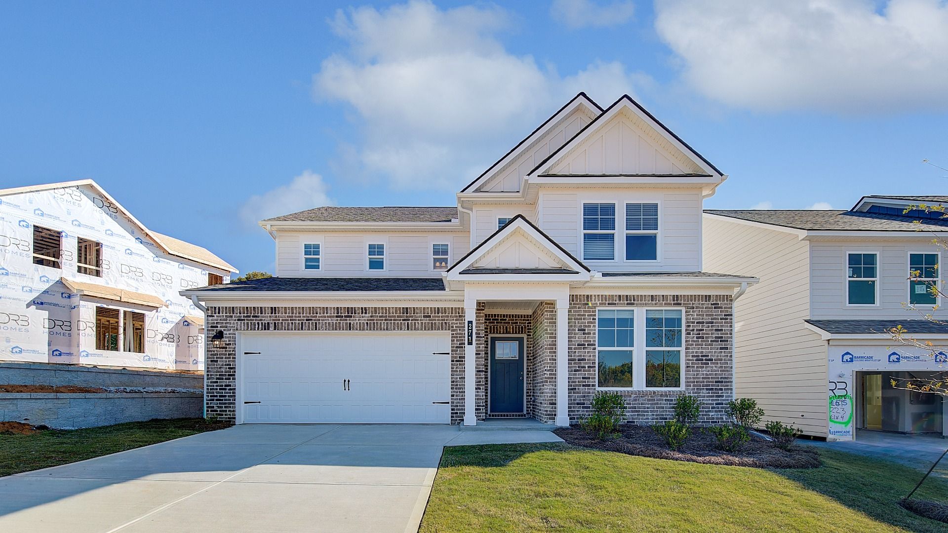 Wynwood elevation 2 exterior with first level brick and two-car front-entry garage at Abbotts Crossing.