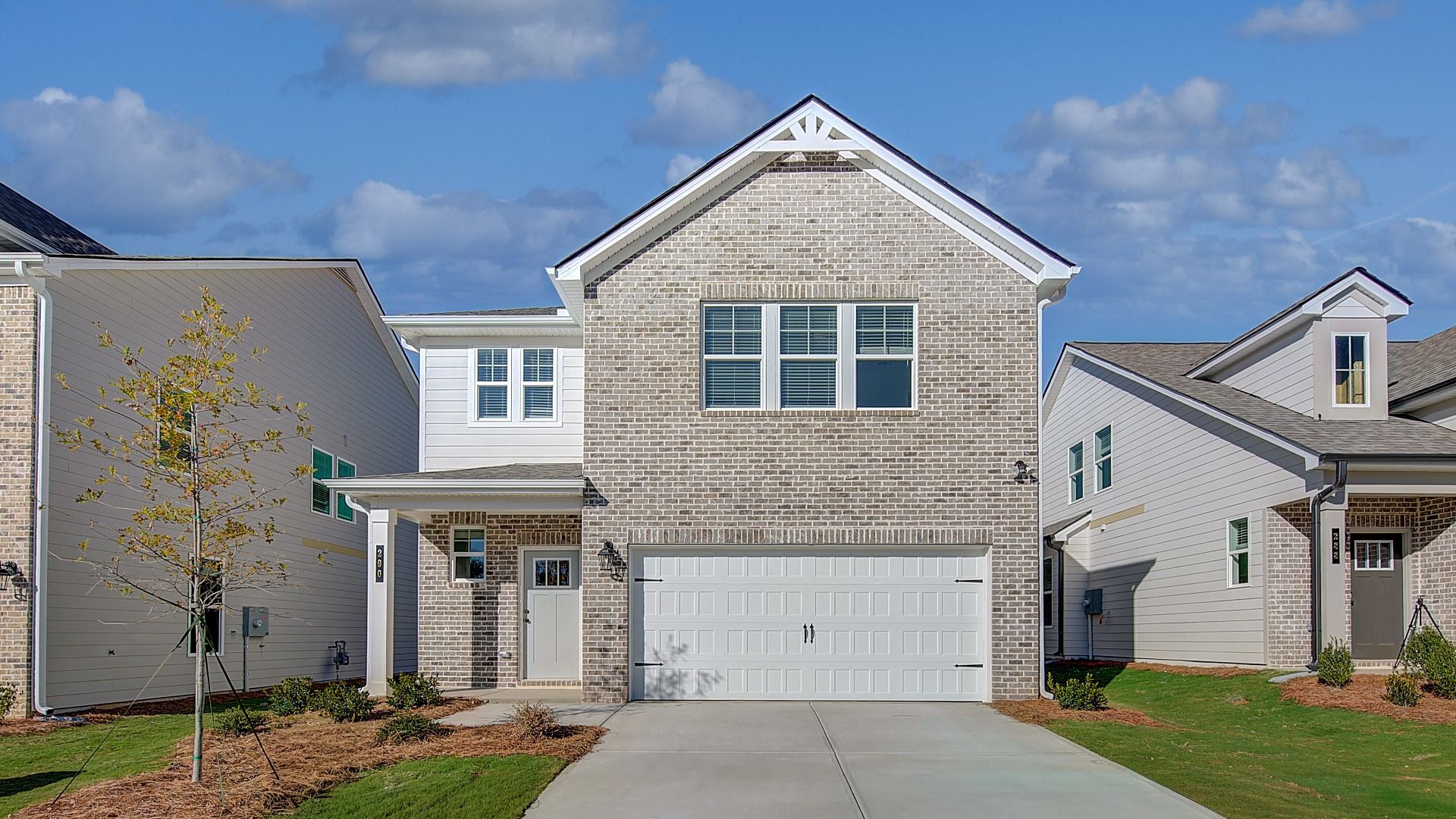 Zoey II elevation 4 brick exterior with siding accent and two-car front entry garage at two-story home in Abbotts Crossing.