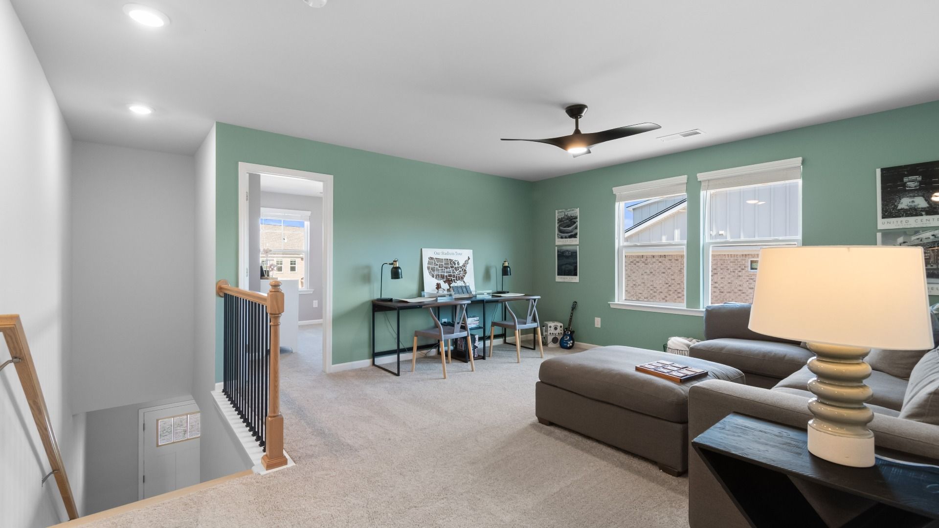 Flexible loft area for lounge or study use featuring carpet flooring and large windows in the Ridgewood at Abbotts Crossing.
