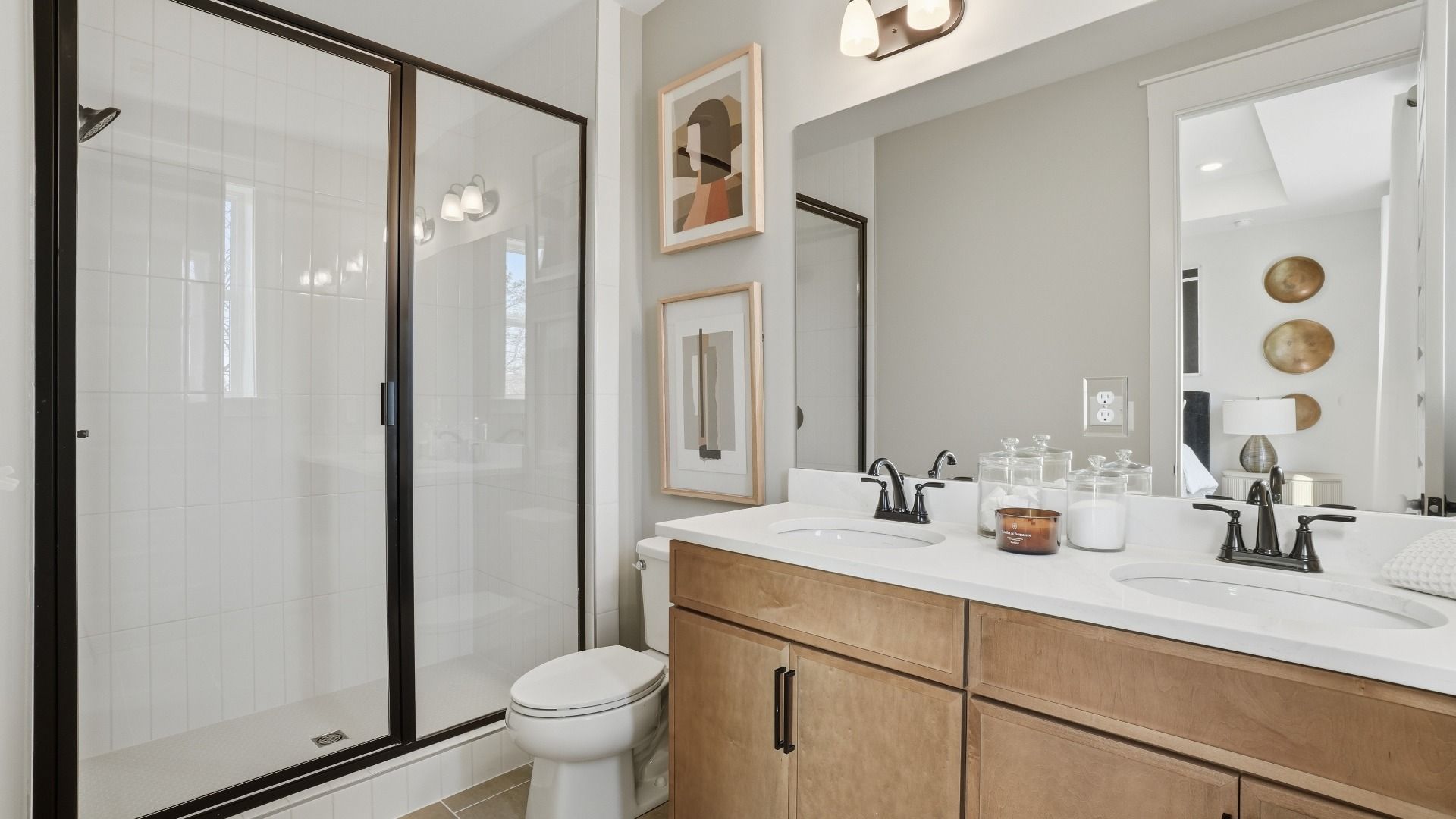 Primary bath with dual vanities, tile-wall walk-in shower, and modern design in the Seaton at Barrett Pointe in Kennesaw, GA.