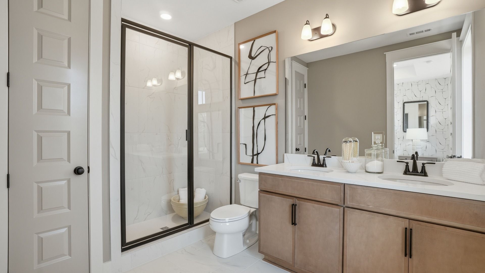Primary bath with tile-wall walk-in shower, dual vanities, and closet in the Seaton at Barrett Pointe in Kennesaw, GA.