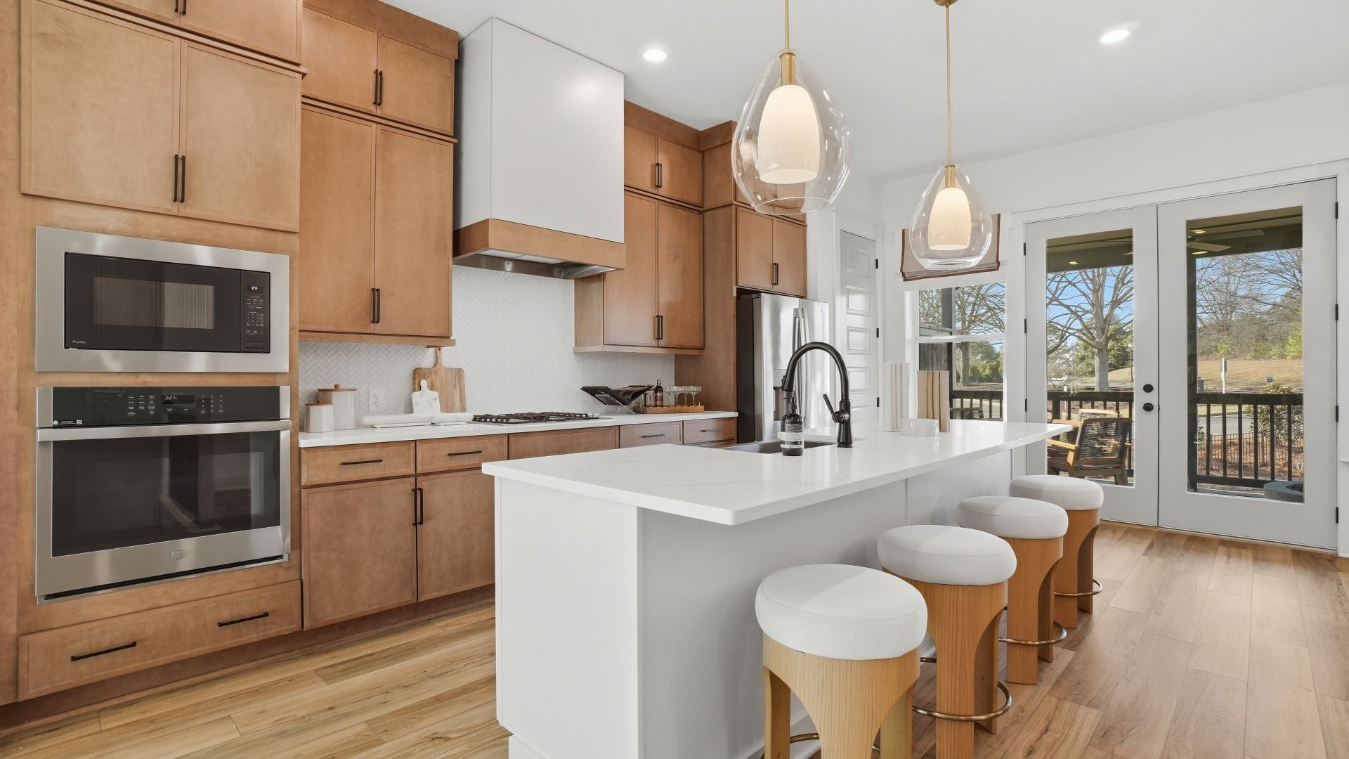 Gourmet kitchen with sleek cabinetry and an oversized island with seating in new construction townhome in Kennesaw, GA.