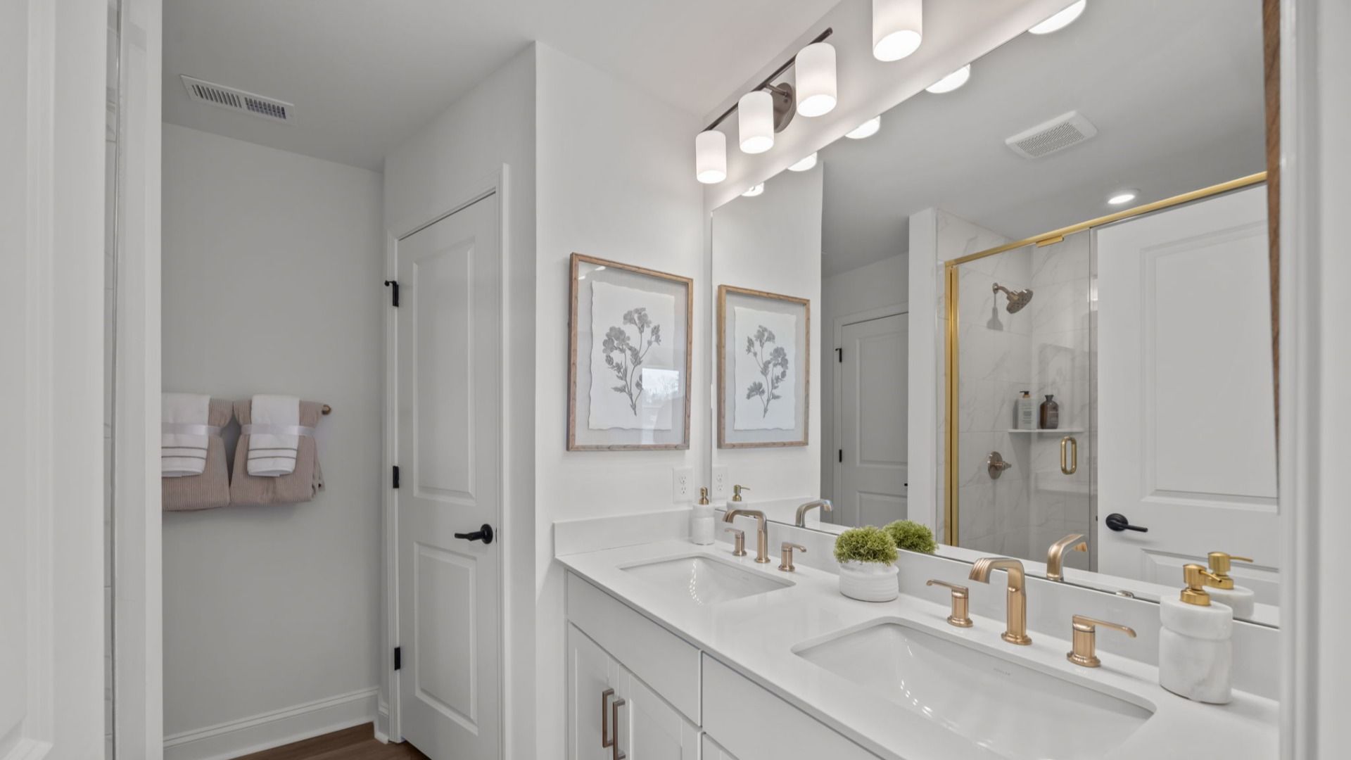 The Rochester Plan by DRB homes primary bathroom in solid white with gold fixtures in Charlotte, NC.