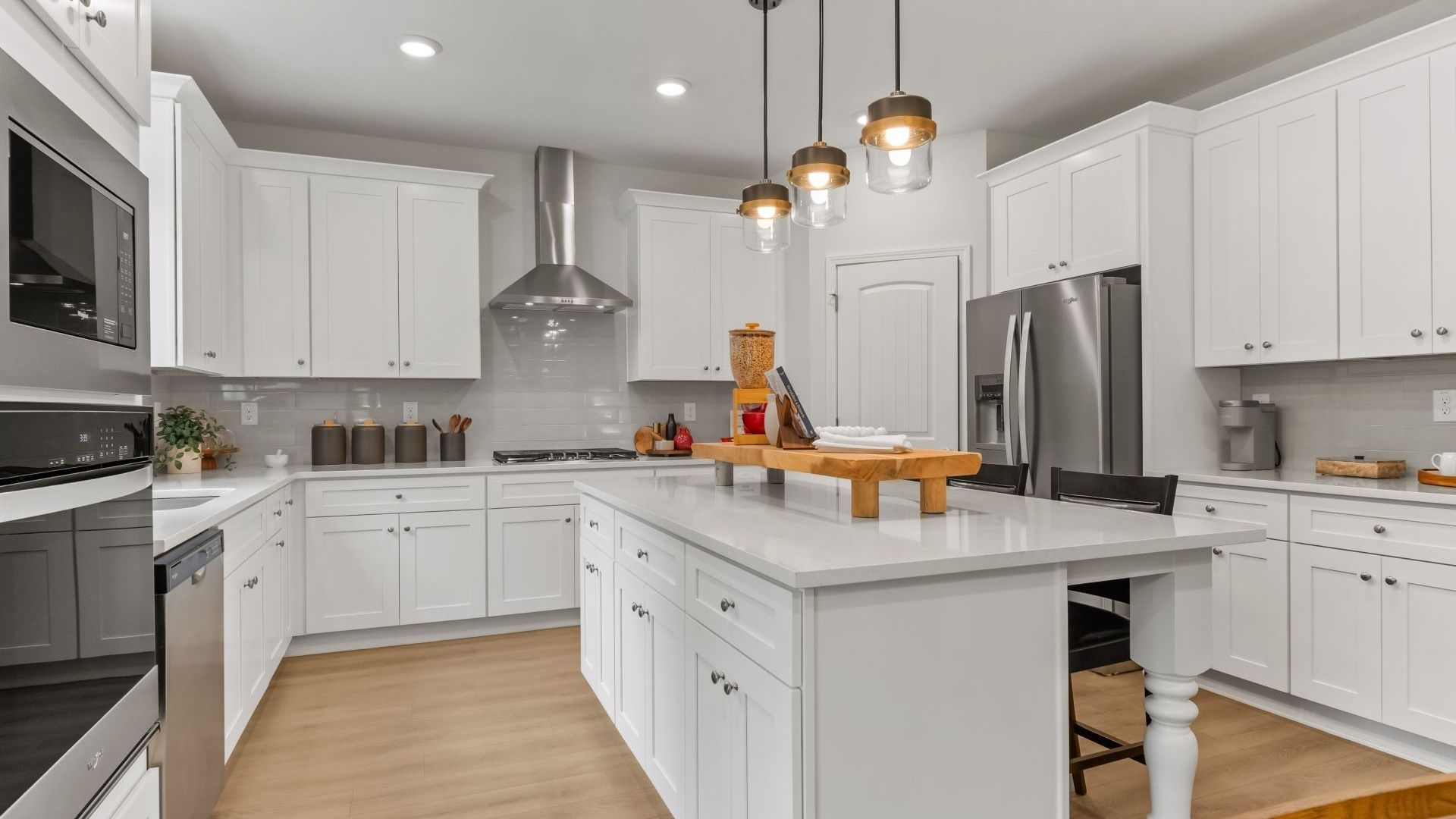 Bright open-concept kitchen featuring central island and abundant white cabinetry in Hamilton Lakes in Lawrenceville, GA.