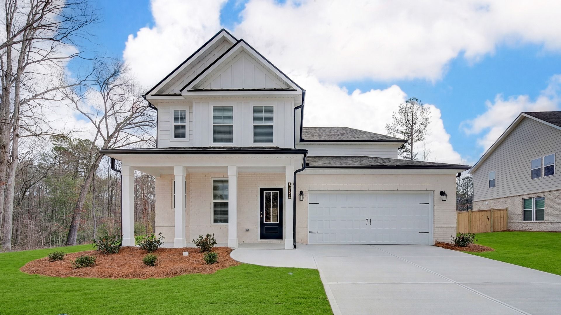 Ansley two-story new construction home with brick, siding, and dark trim in Lawrenceville, GA.