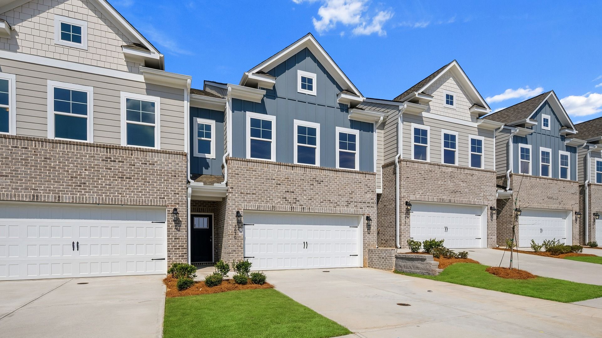 New construction townhomes with brick accents and 2-car garages at Langley Overlook in Loganville, GA.