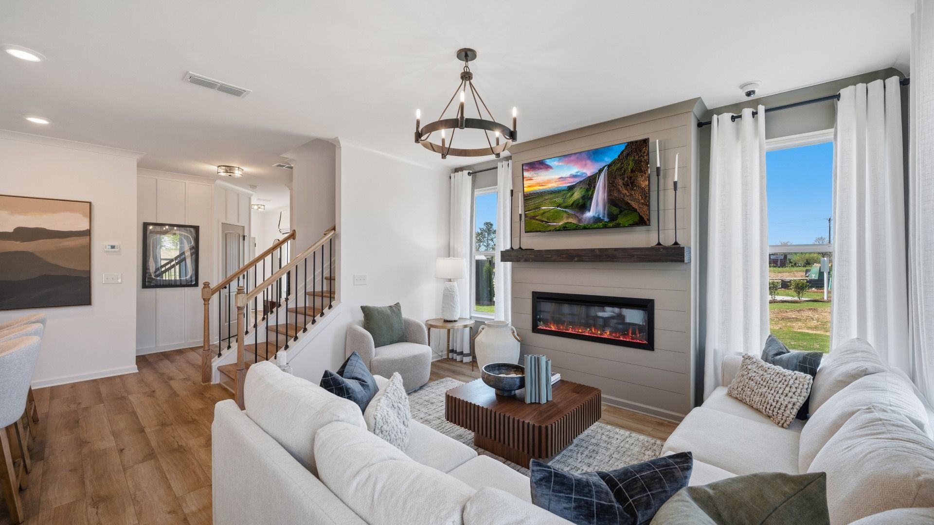 Open family living space with electric fireplace and modern finishes in Langley Overlook new construction townhome.