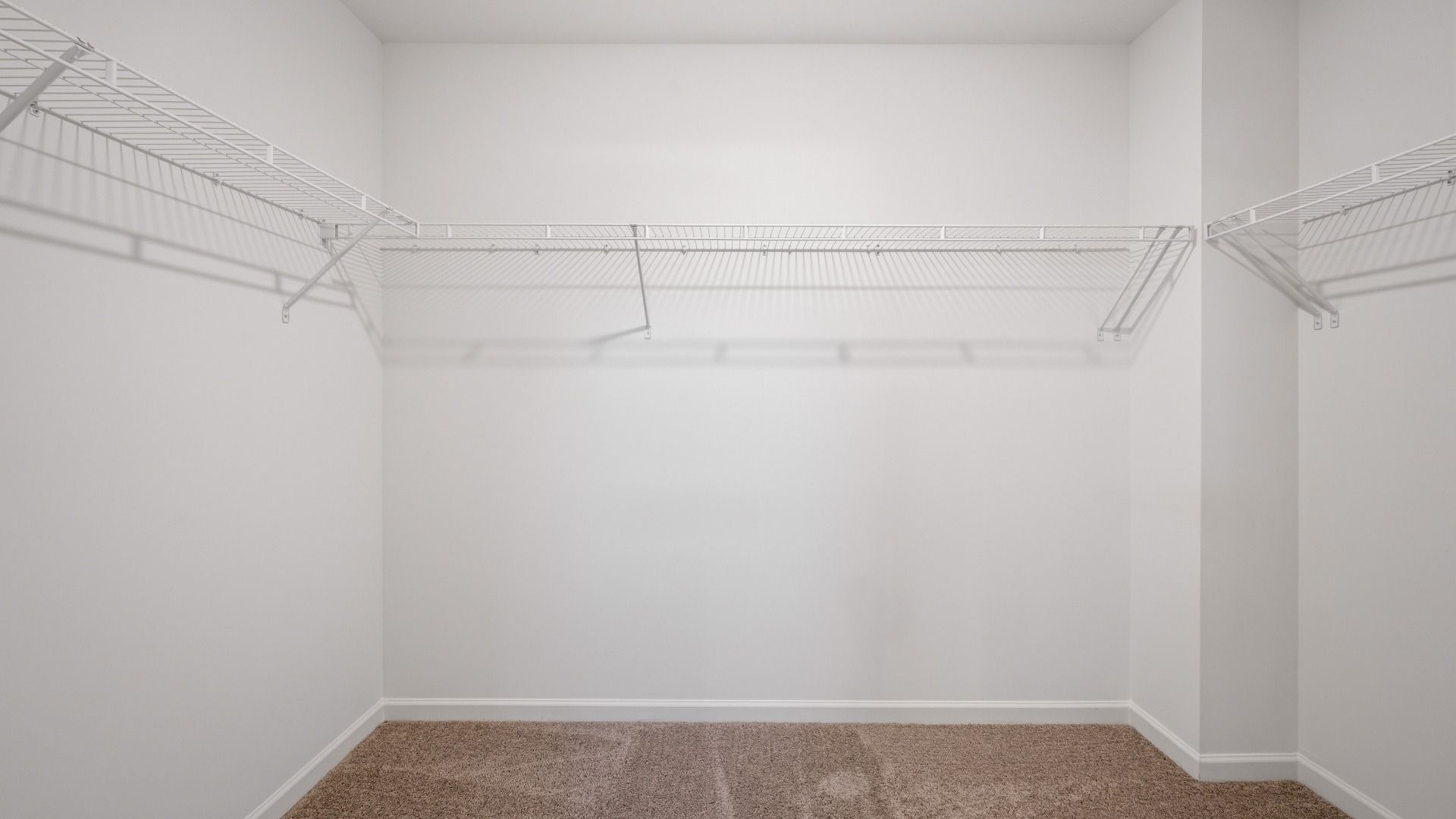 Walk-in closet with built-in shelving and ample storage in Langley Overlook townhome in Loganville, GA.