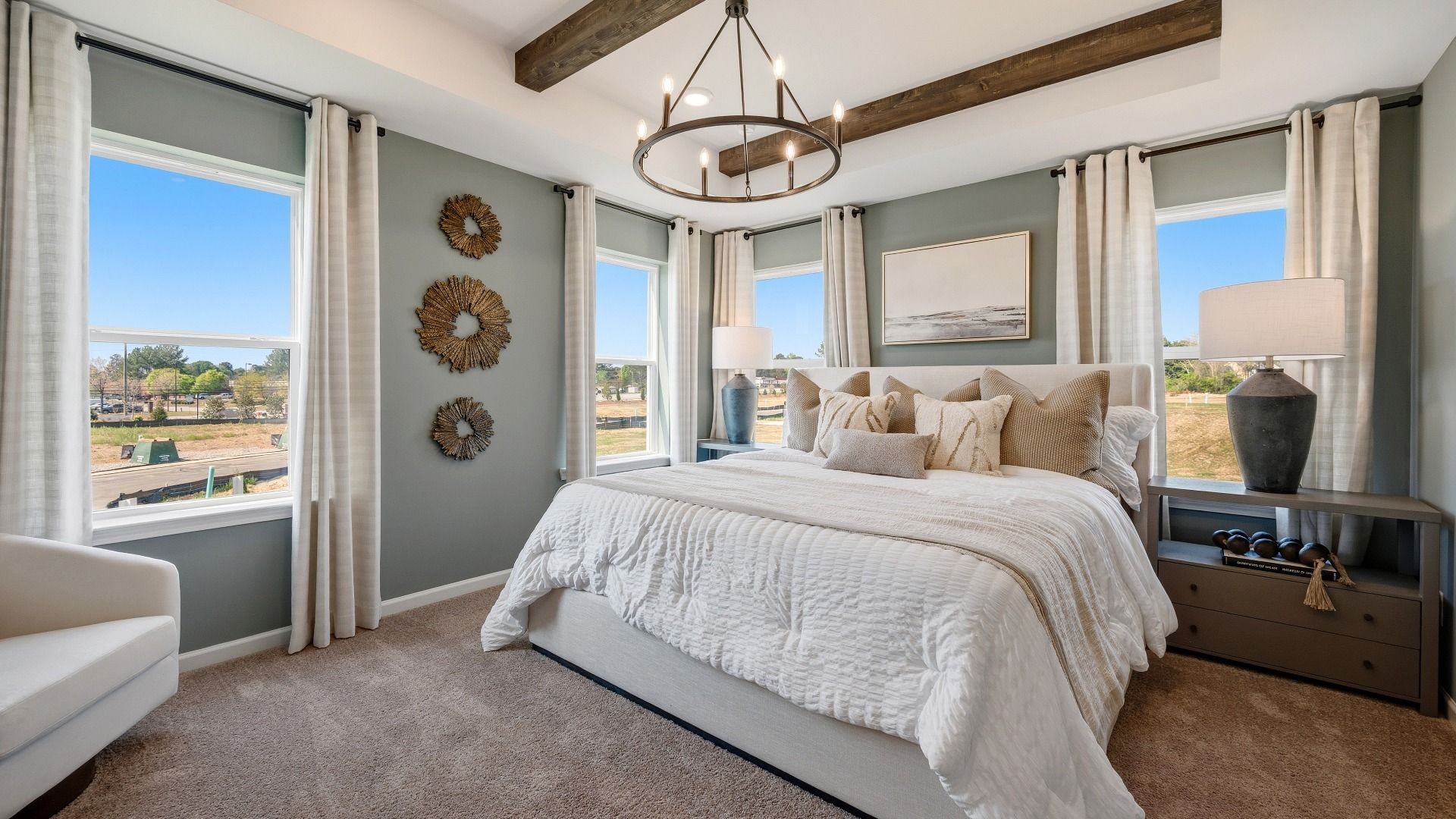 Spacious primary suite with large windows, modern décor, and natural light in Langley Overlook townhome in Loganville, GA.