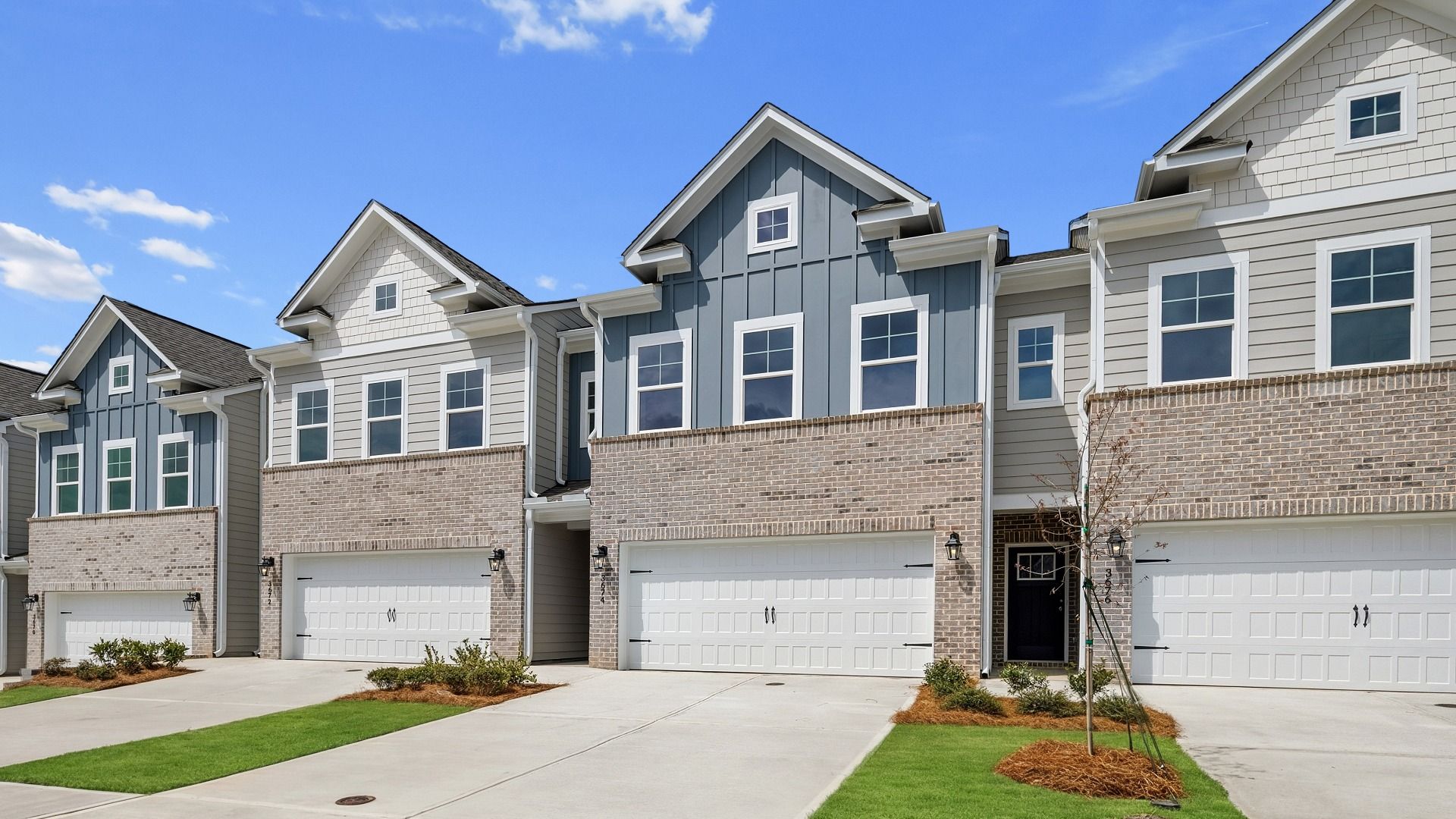 Two-story Luca townhome with a brick-siding exterior, modern trim, and a welcoming entry in the Langley Overlook community.