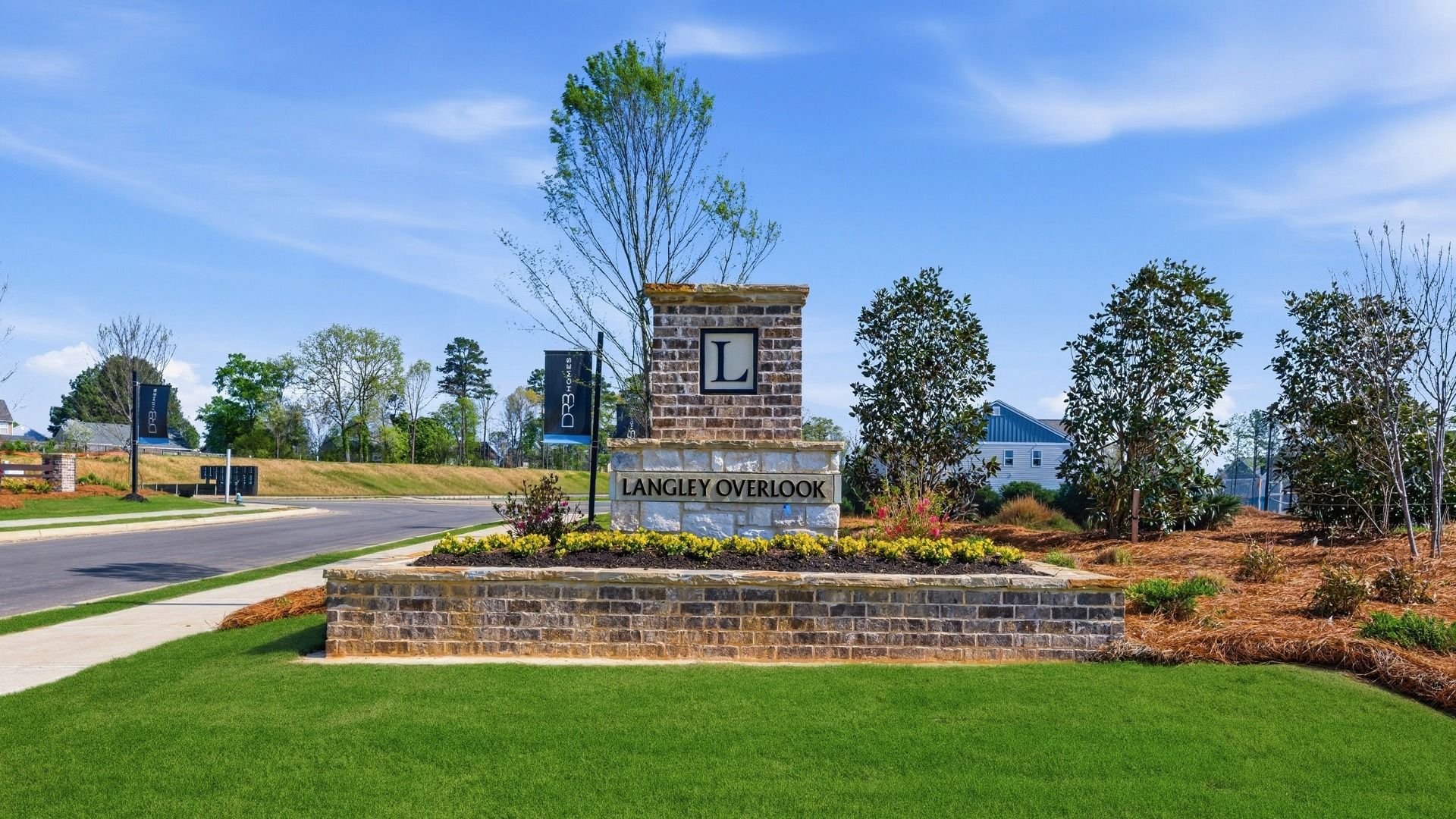 Langley Overlook townhome entrance with stone and brick monument and landscaped surroundings.
