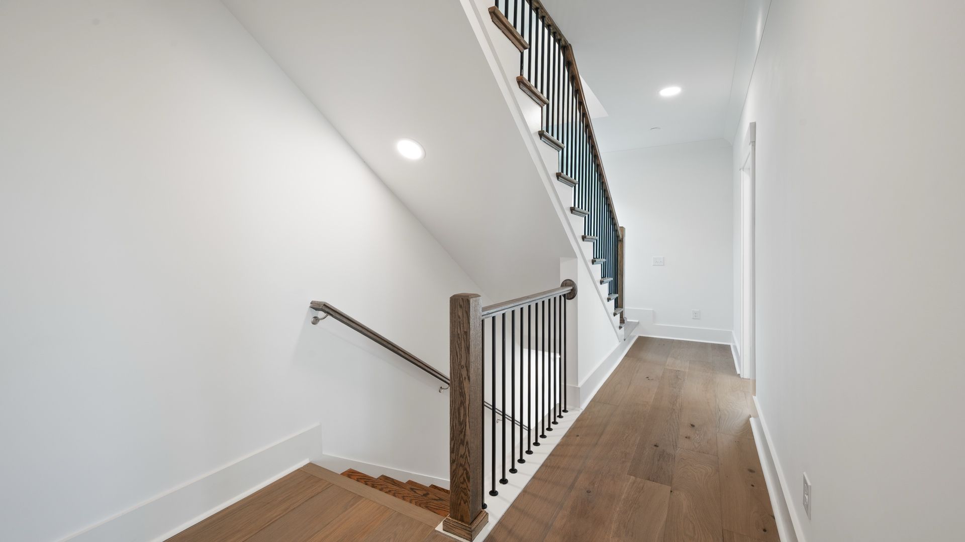Second-floor hallway in the Sullivan home plan featuring hardwood flooring and access to the primary suite.