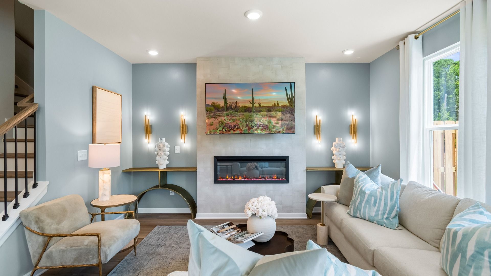 Spacious family room with electric fireplace, large windows, and open layout in new construction townhome.