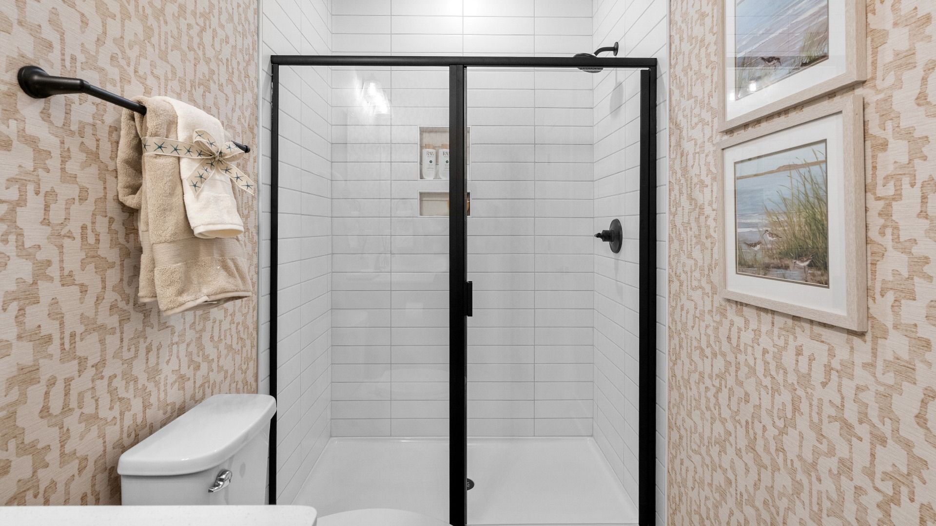 Secondary bathroom shower in the Summit home plan with stylish tile and elegant finishes.