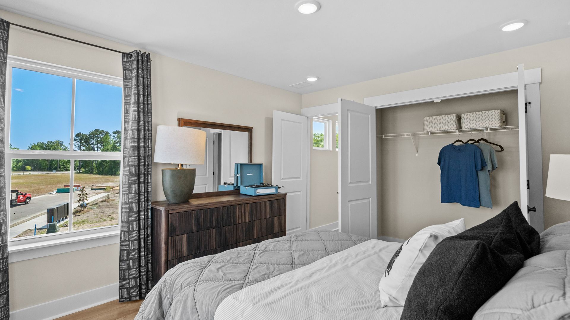 Spacious second-floor bedroom in the Summit home plan with natural light and style.