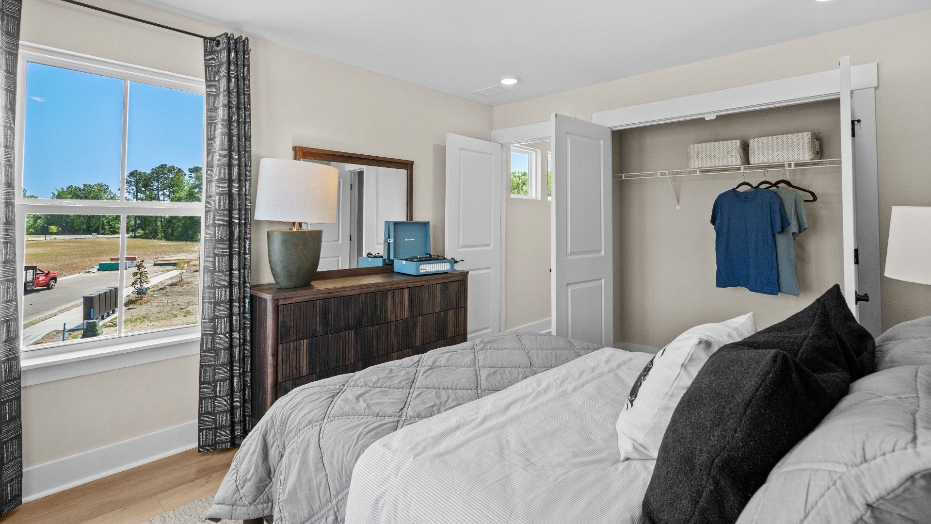 Spacious second-floor bedroom in the Summit home plan with natural light and style.