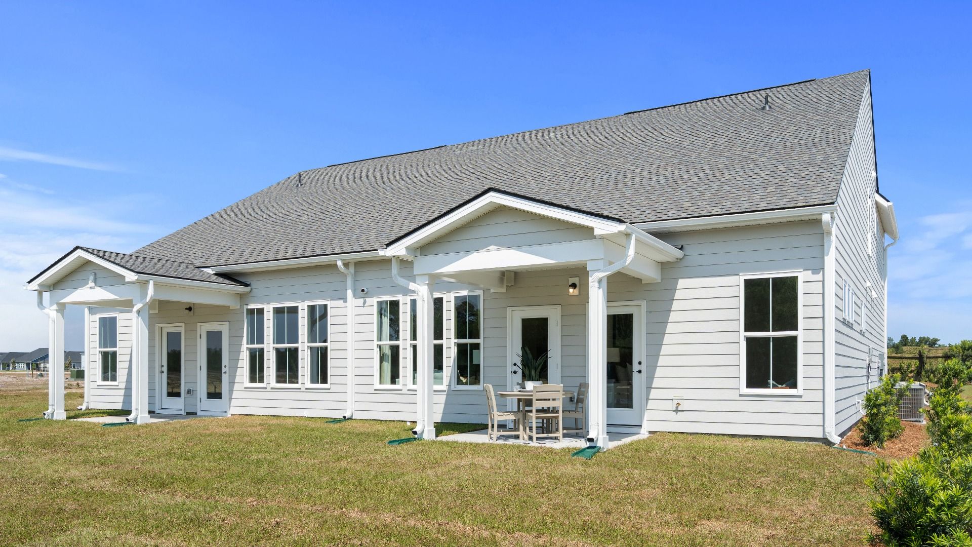 Rear exterior of the Summit home plan showcasing covered outdoor living and villa design.