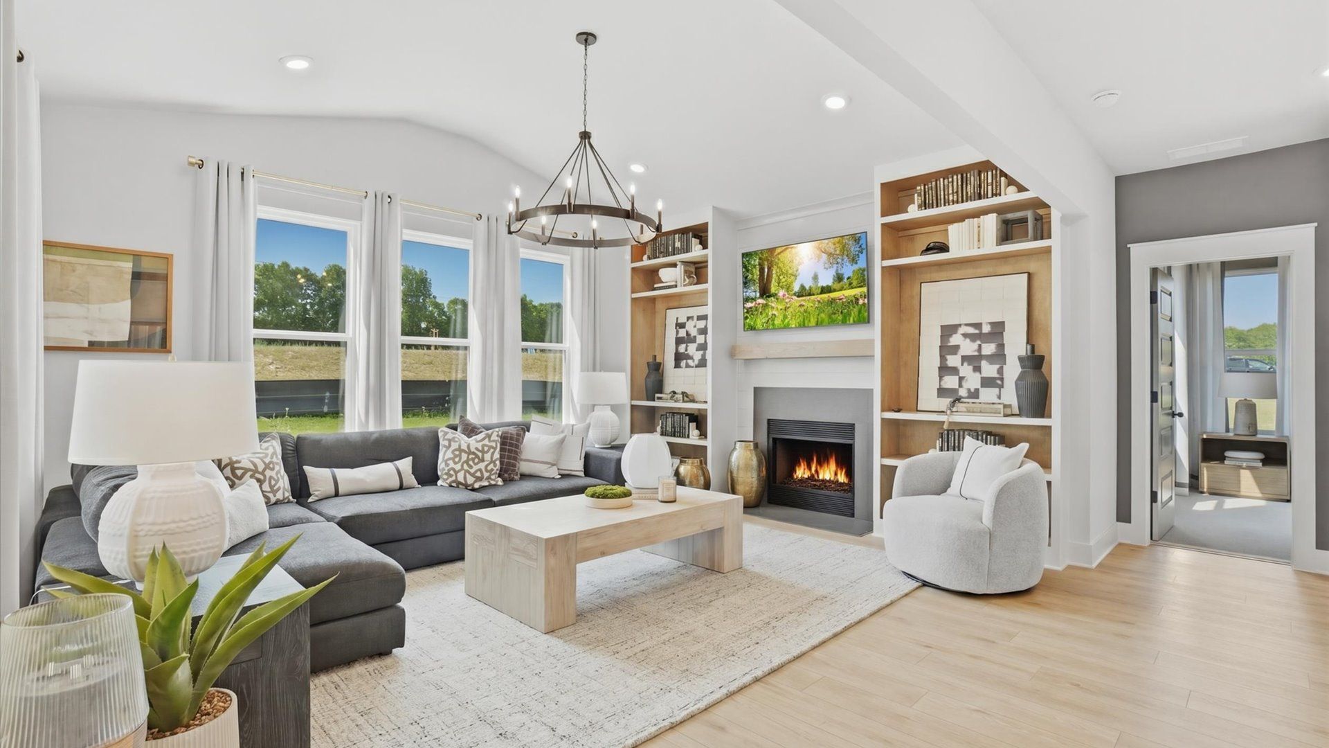 Bright family room featuring gas fireplace, built-in shelves, and open layout at Northcroft in Loganville, GA.