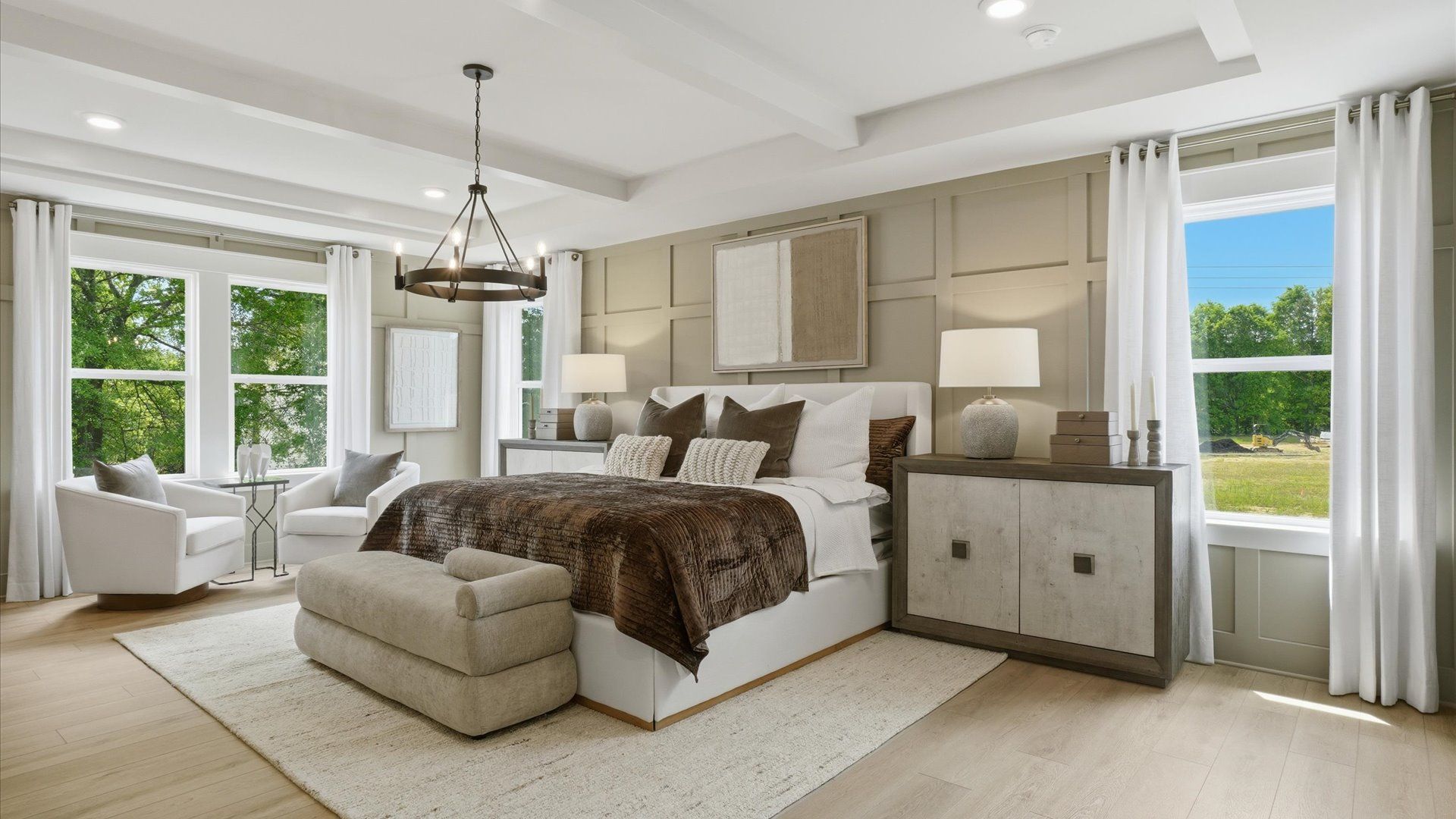 Spacious primary suite featuring elevated modern design and sitting area at Northcroft in Loganville, GA.