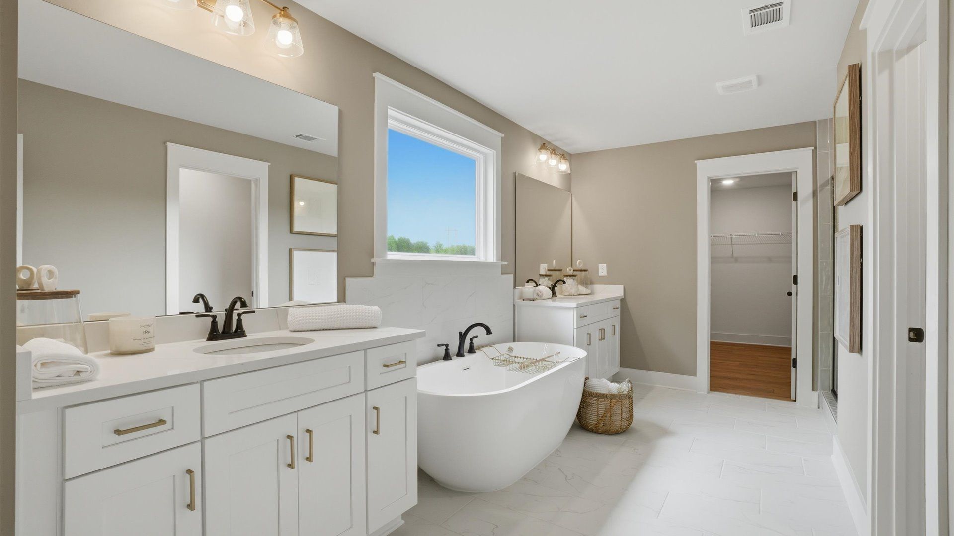 Primary bath featuring bright, clean modern finishes with dual sinks and free-standing tub at Northcroft in Loganville, GA.