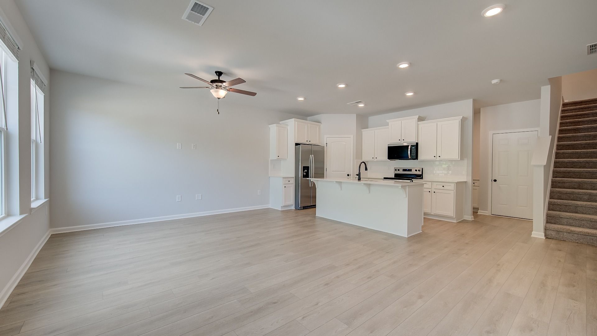 Mitchell open-concept family room with LVP flooring and natural light in new construction townhome at Avery Landing.