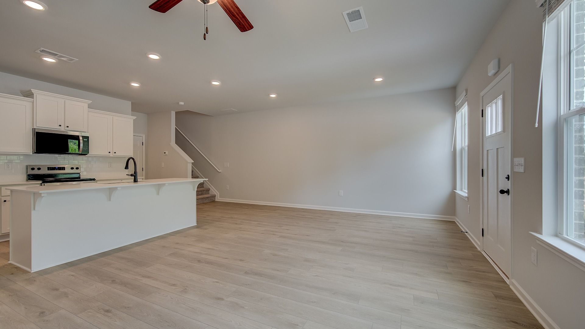 Open-concept family room with overhead fan, natural light and LVP flooring in the Mitchell at Adagio.