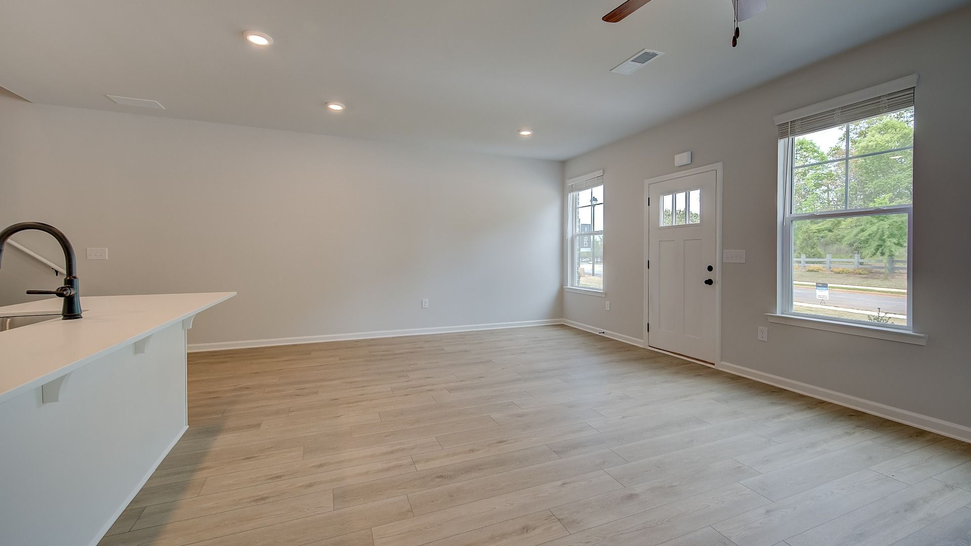 Open-concept family room with overhead fan, natural light and LVP flooring in the Mitchell at Adagio.