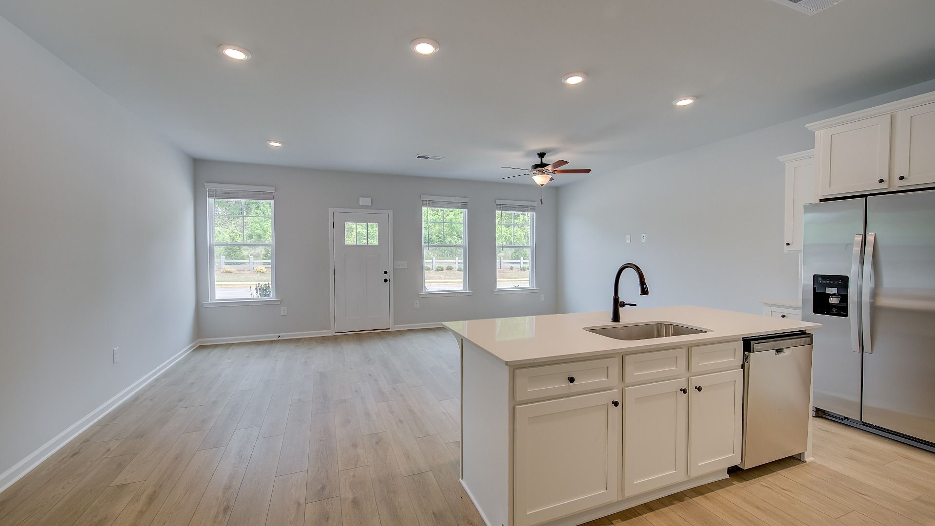 Open-concept kitchen with center island, stainless appliances, and LVP flooring in the Mitchell at Avery Landing.