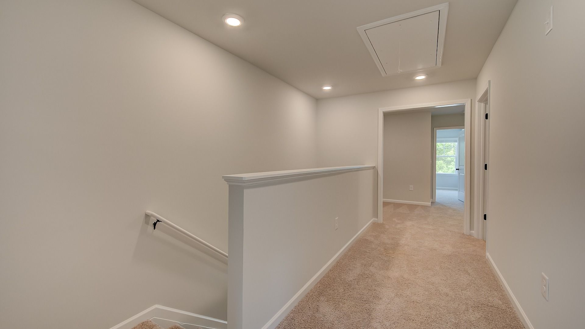 Upstairs landing with open hallway and carpet flooring in the Mitchell at Avery Landing in McDonough, GA.