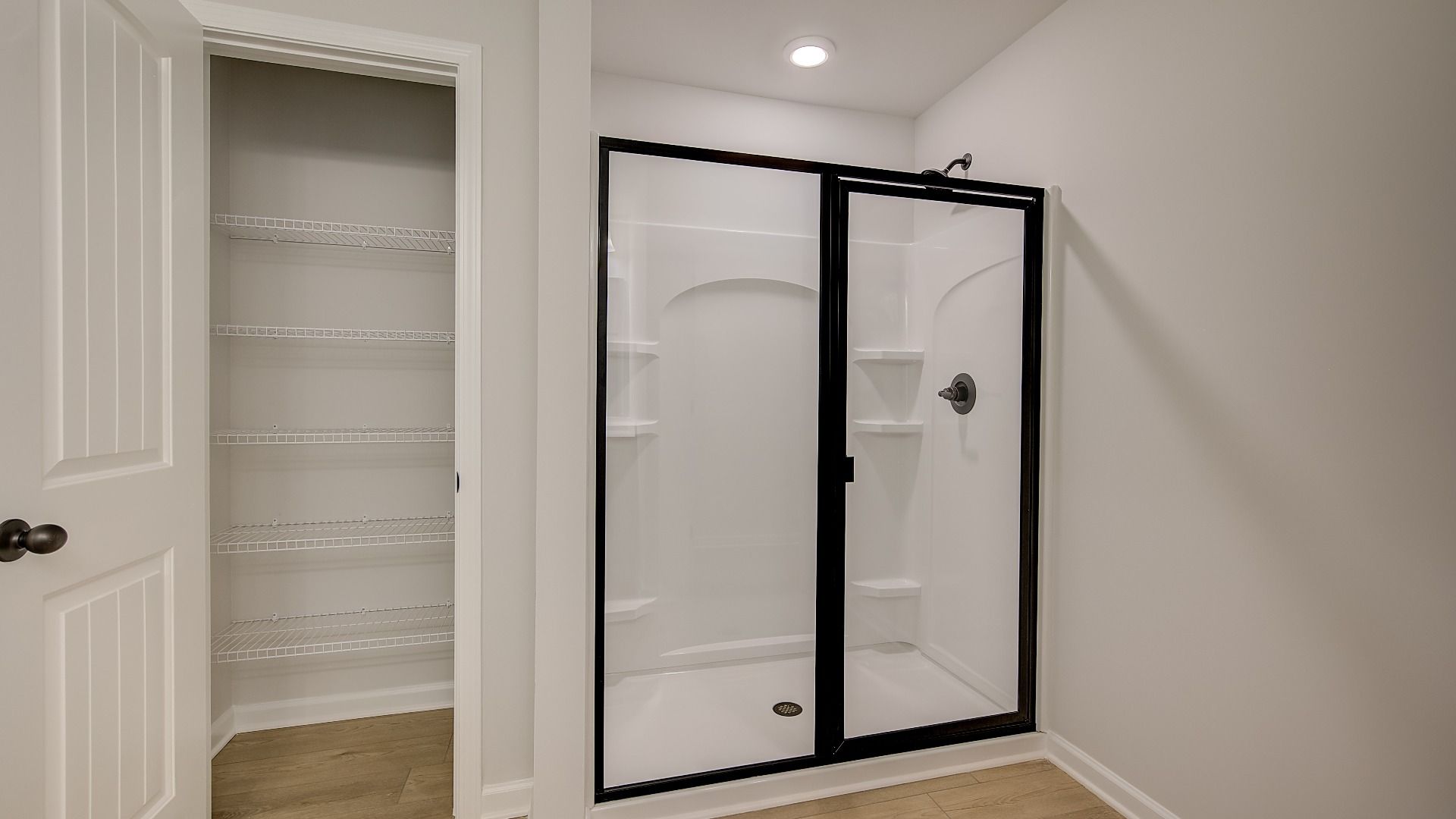 Primary bath with walk-in shower and a closet with built-in shelving in the Mitchell at Avery Landing.
