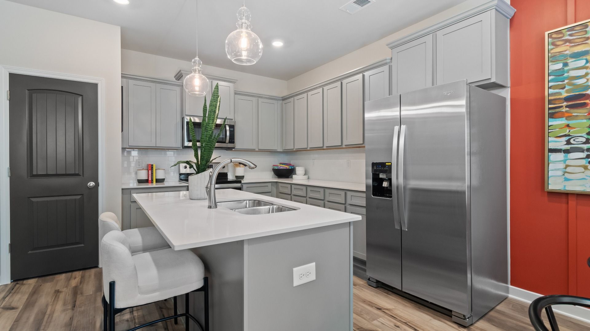 Kitchen with gray cabinets, large island and stainless appliances at Avery Landing in McDonough, GA