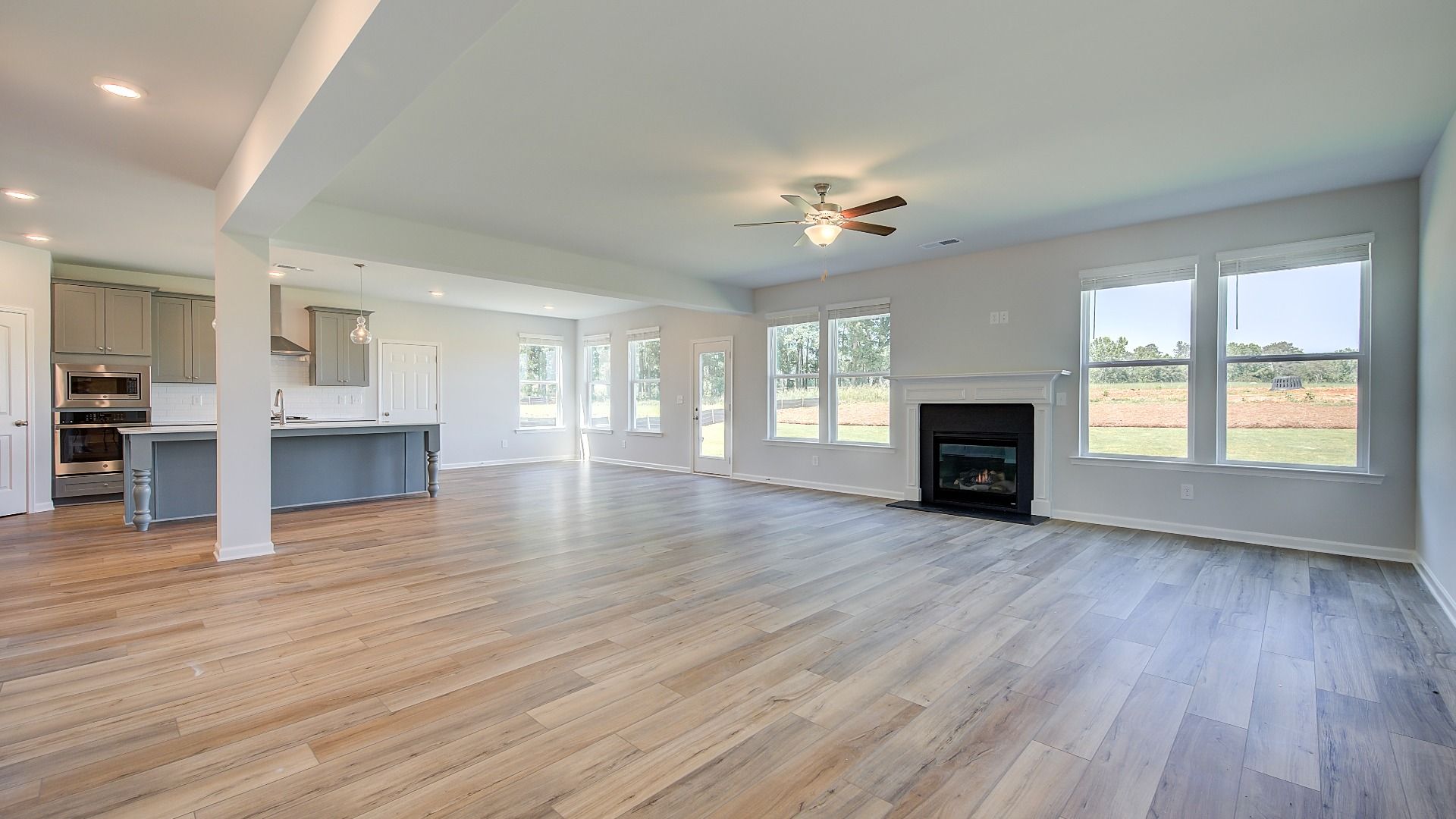 Open-concept family room with gas fireplace and LVP flooring in the Clarity at Brighton in Locust Grove, GA.