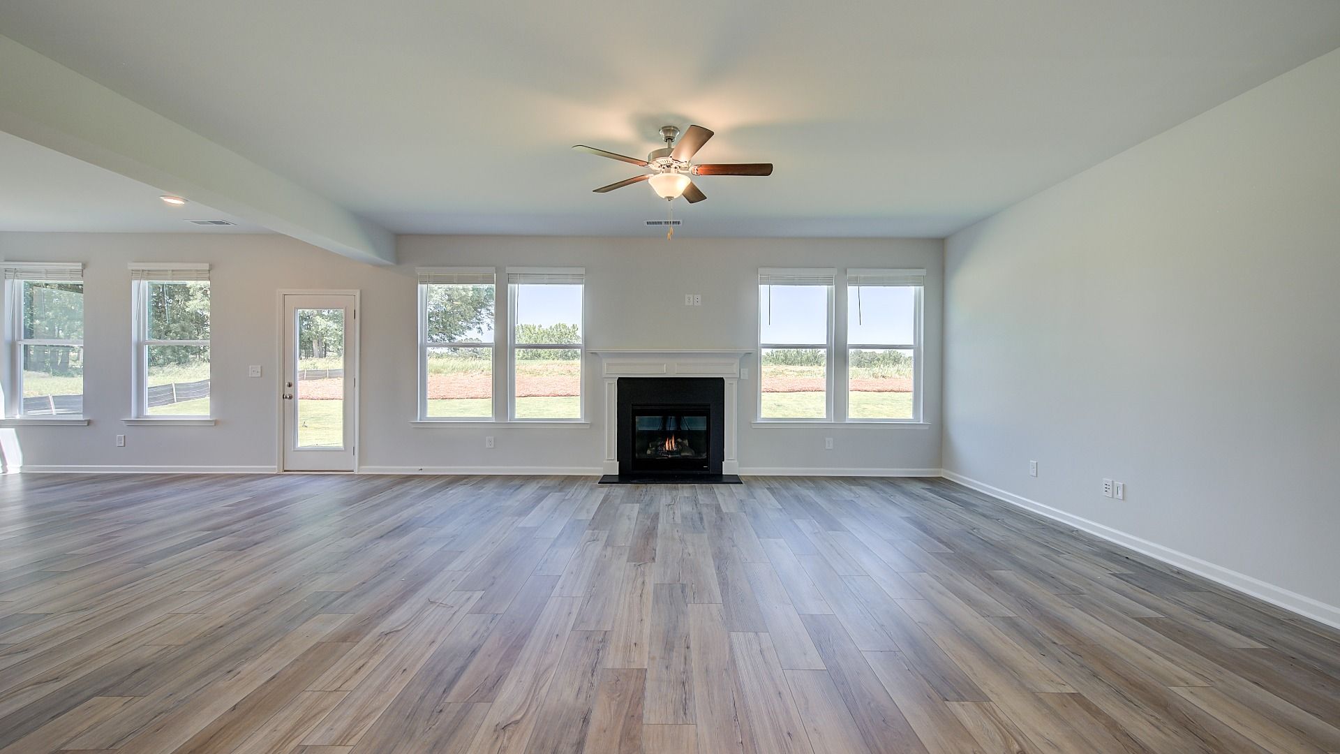 Expansive family room with gas fireplace and LVP flooring in the Clarity at Brighton in Locust Grove, GA.