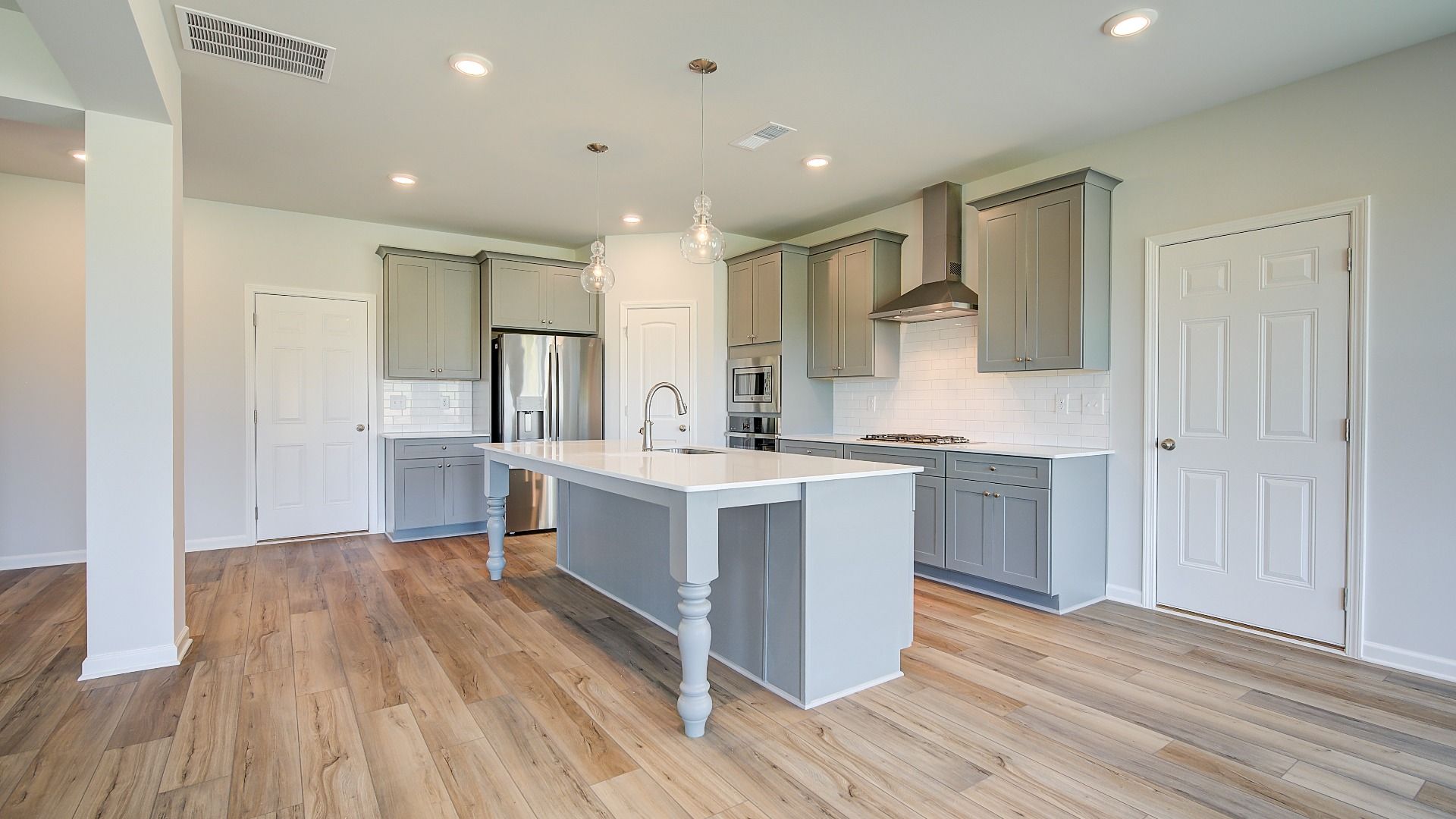 Modern kitchen with neutral cabinetry and oversized island in the Clarity at Brighton in Locust Grove, GA.