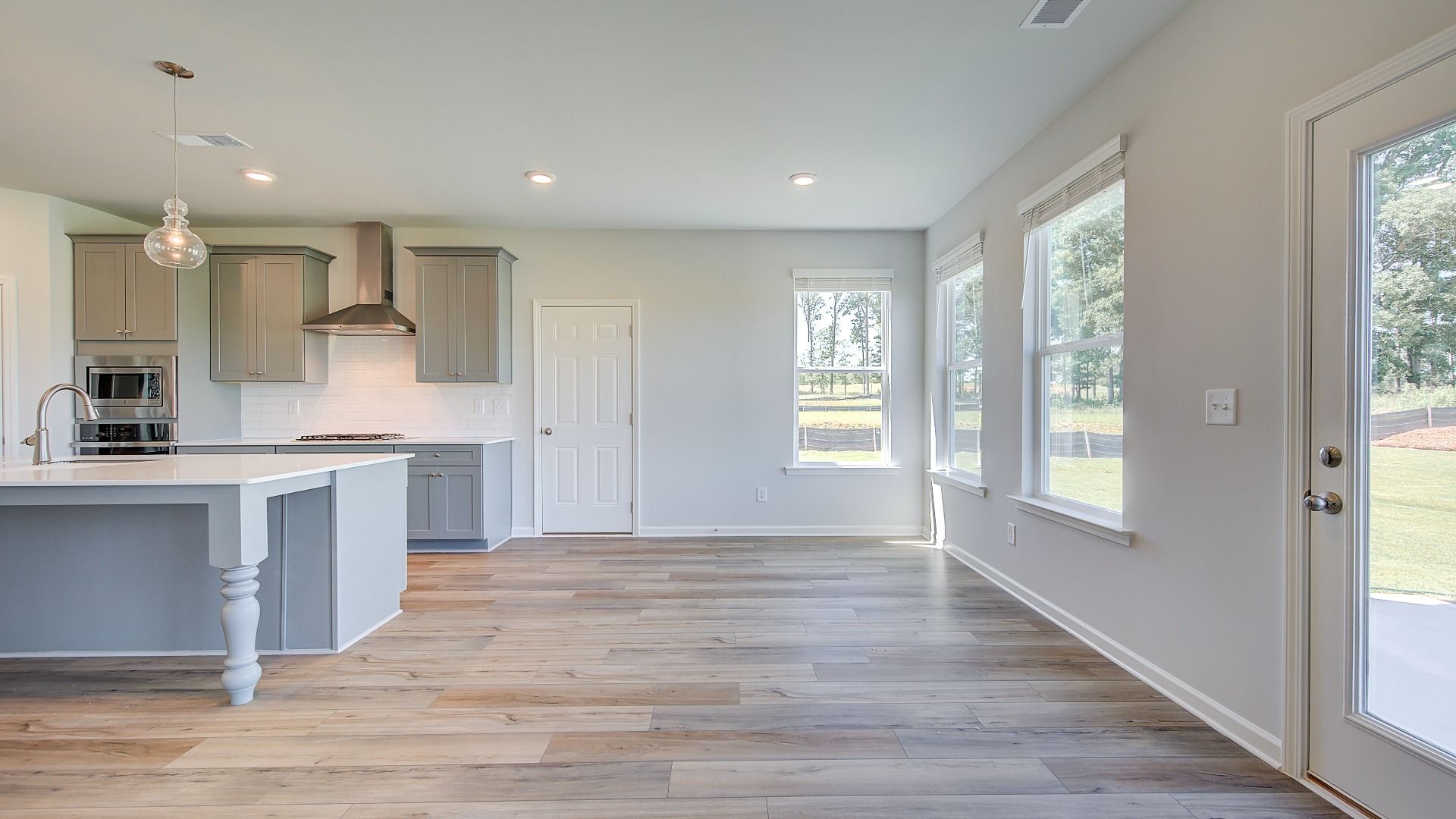 Bright breakfast room connected to kitchen with LVP flooring and view of covered porch in the Clarity at Brighton.