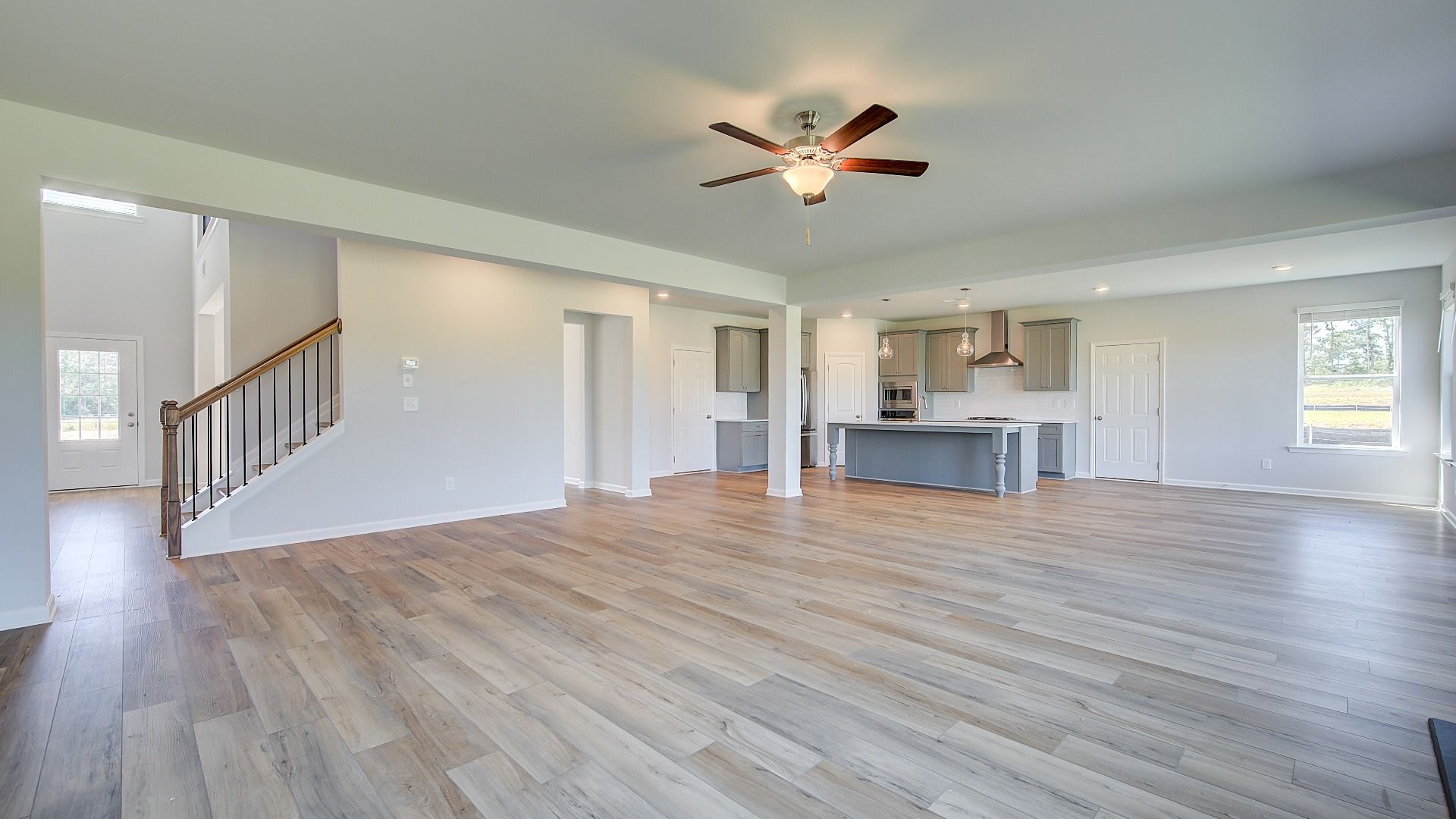 Clarity open-concept family room with LVP flooring and view of kitchen and breakfast area at Brighton in Locust Grove, GA.