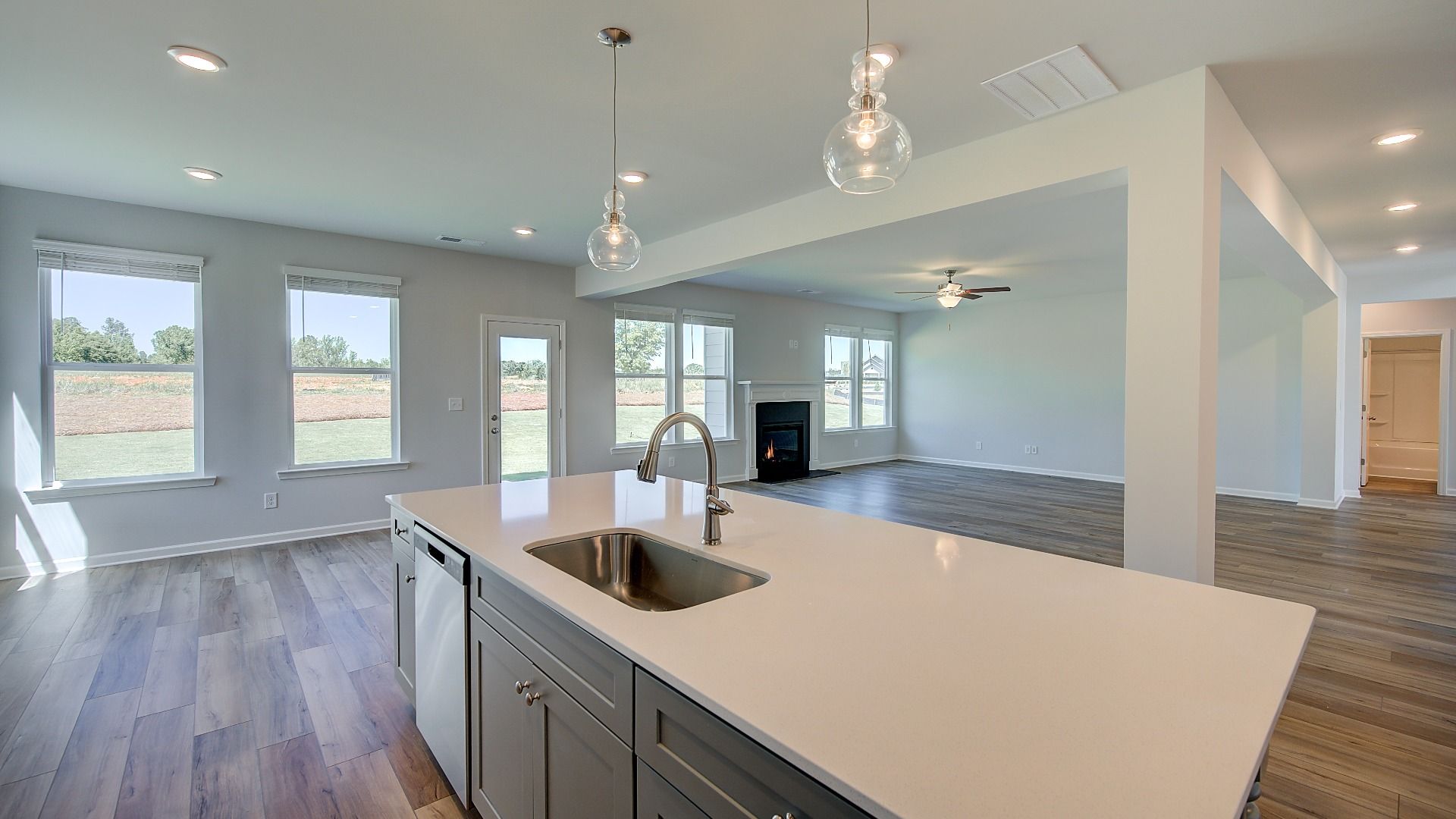 Clarity kitchen with white tile backsplash and large island overlooking family room at Brighton in Locust Grove, GA.