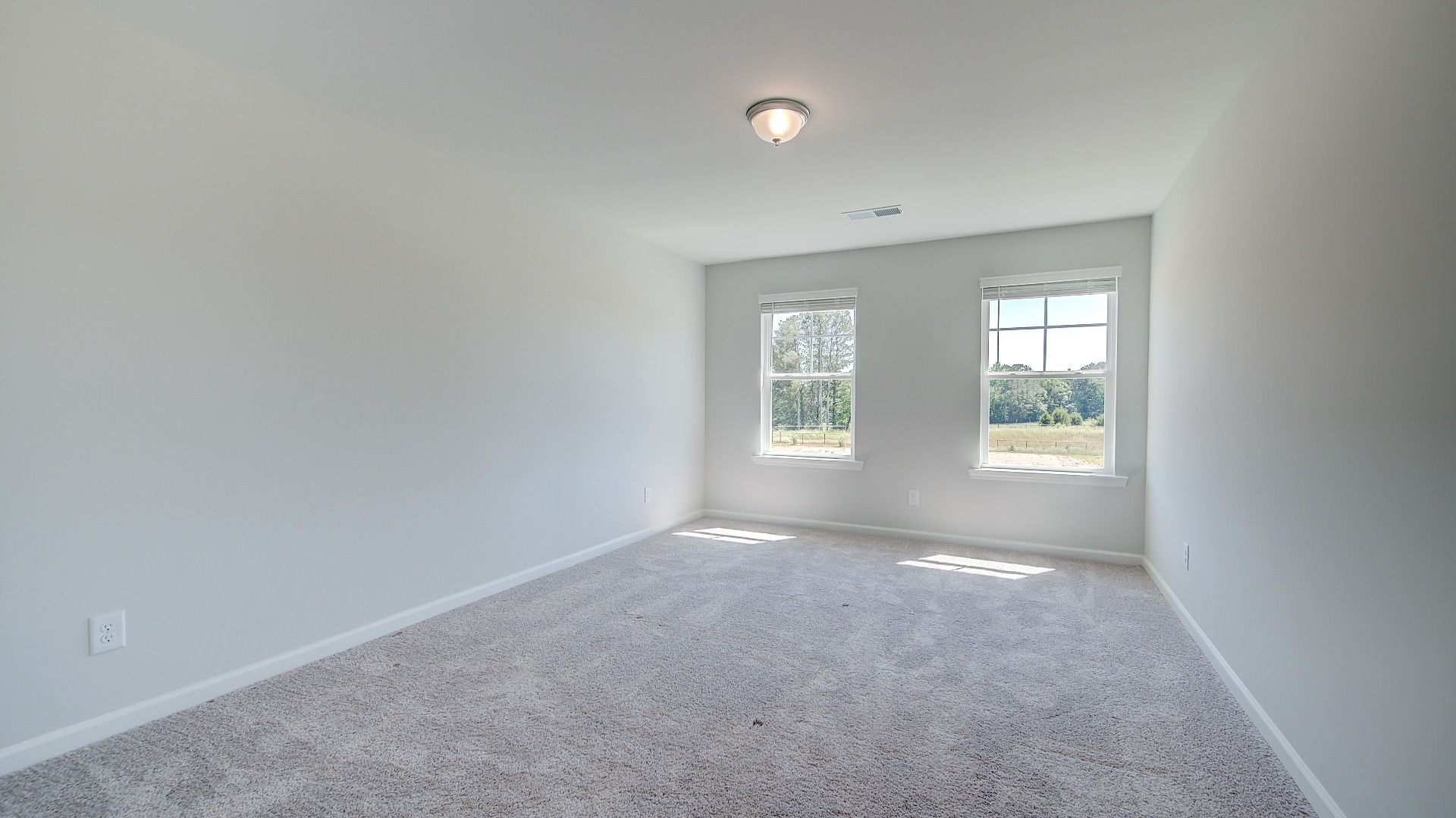 Secondary bedroom with neutral walls, carpet flooring, and natural light in the Clarity at Brighton in Locust Grove, GA.