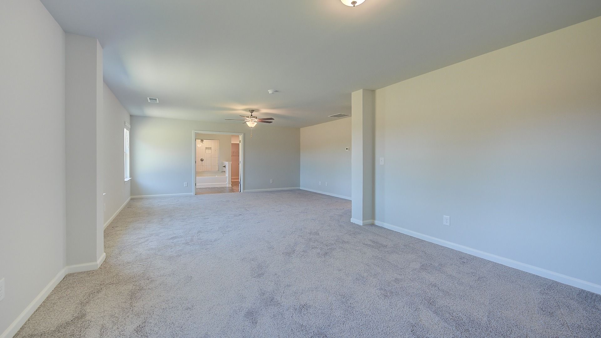 Clarity primary sitting room connected to the suite with carpet flooring and neutral walls at Brighton in Locust Grove, GA.