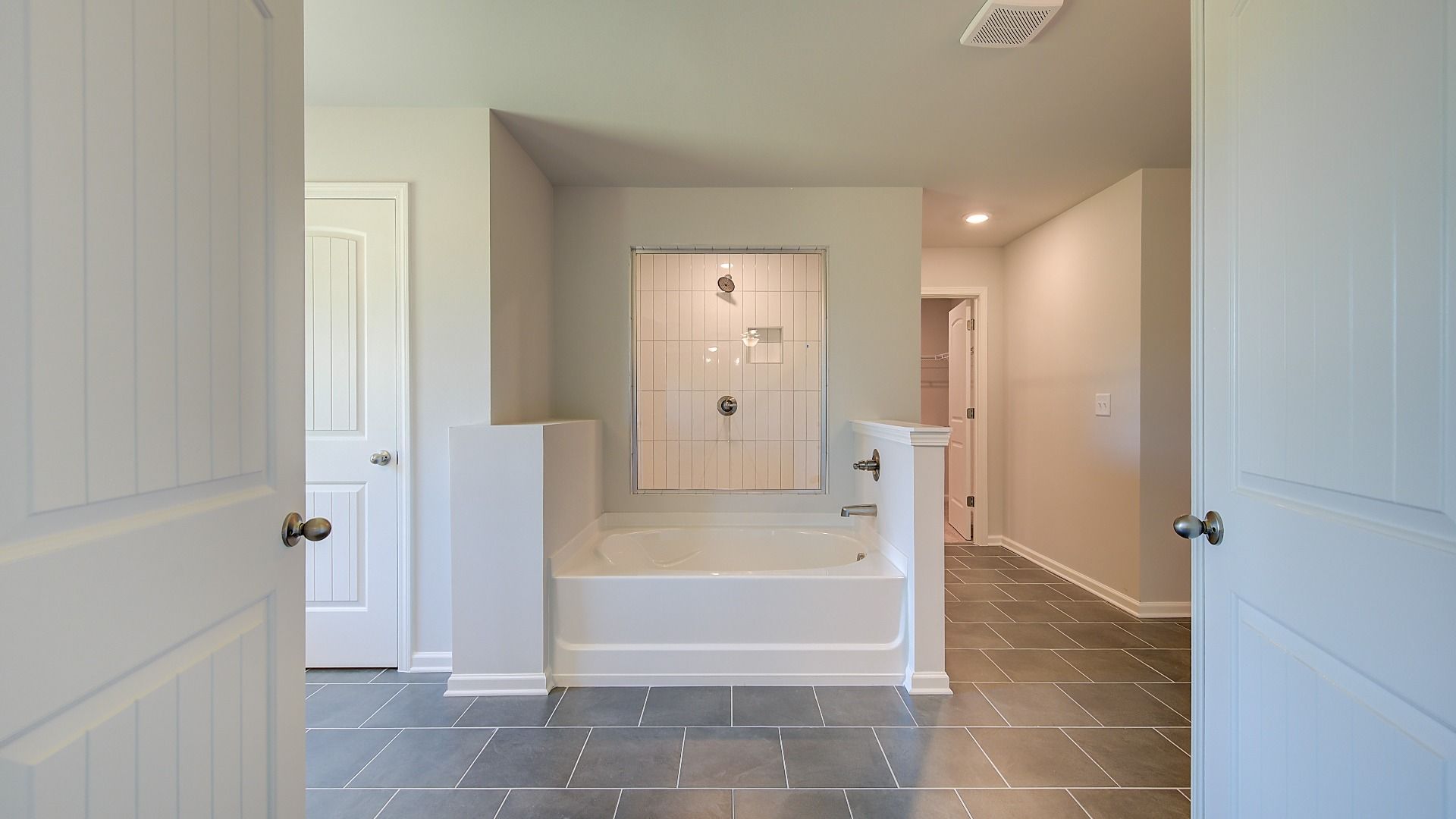 Primary bath with modern tile floor and freestanding tub in the Clarity at Brighton in Locust Grove, GA.
