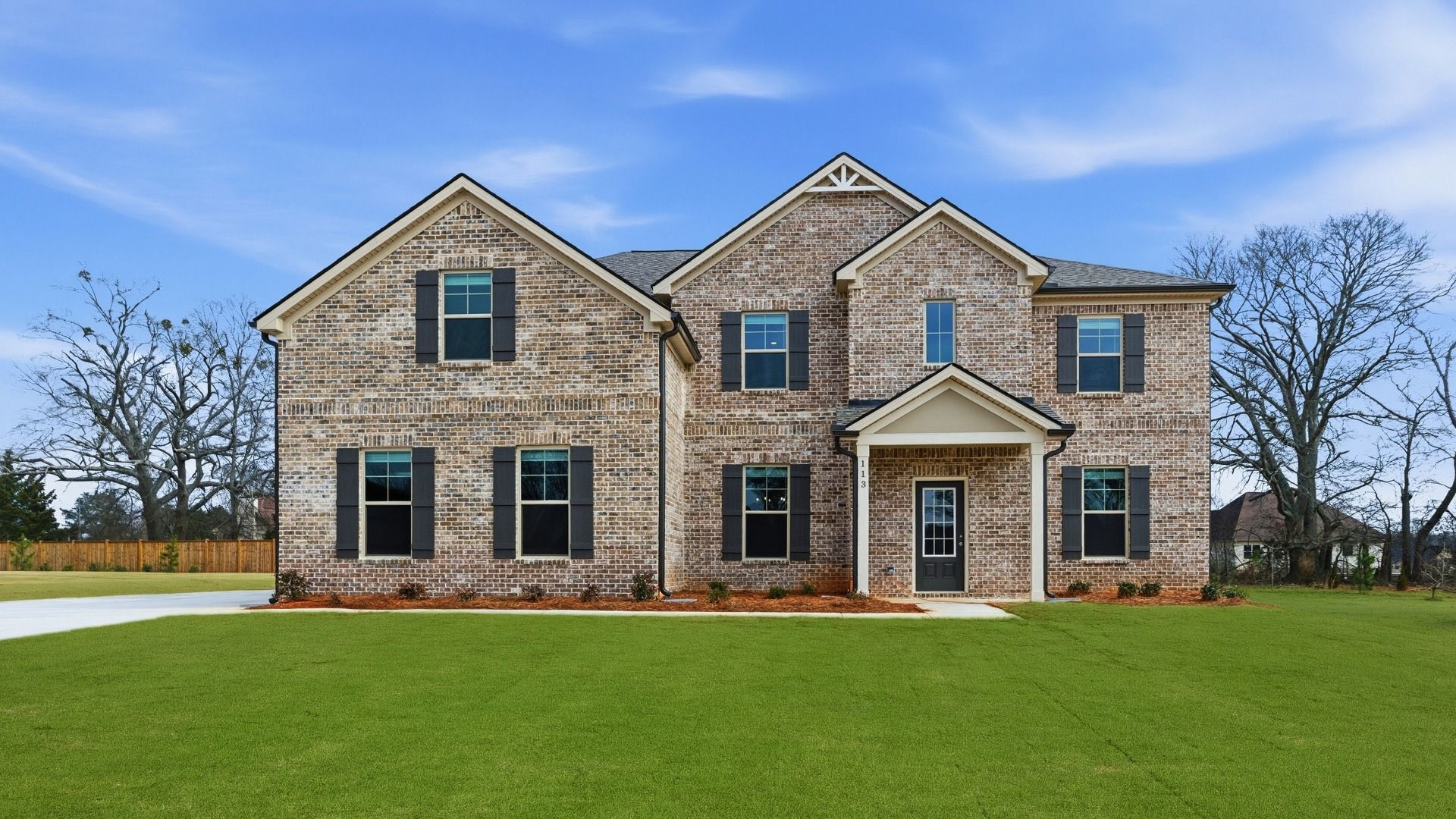 Meridian model two-story home with four-sided brick exterior, side-entry garage, and ample front yard area in Hampton, GA.