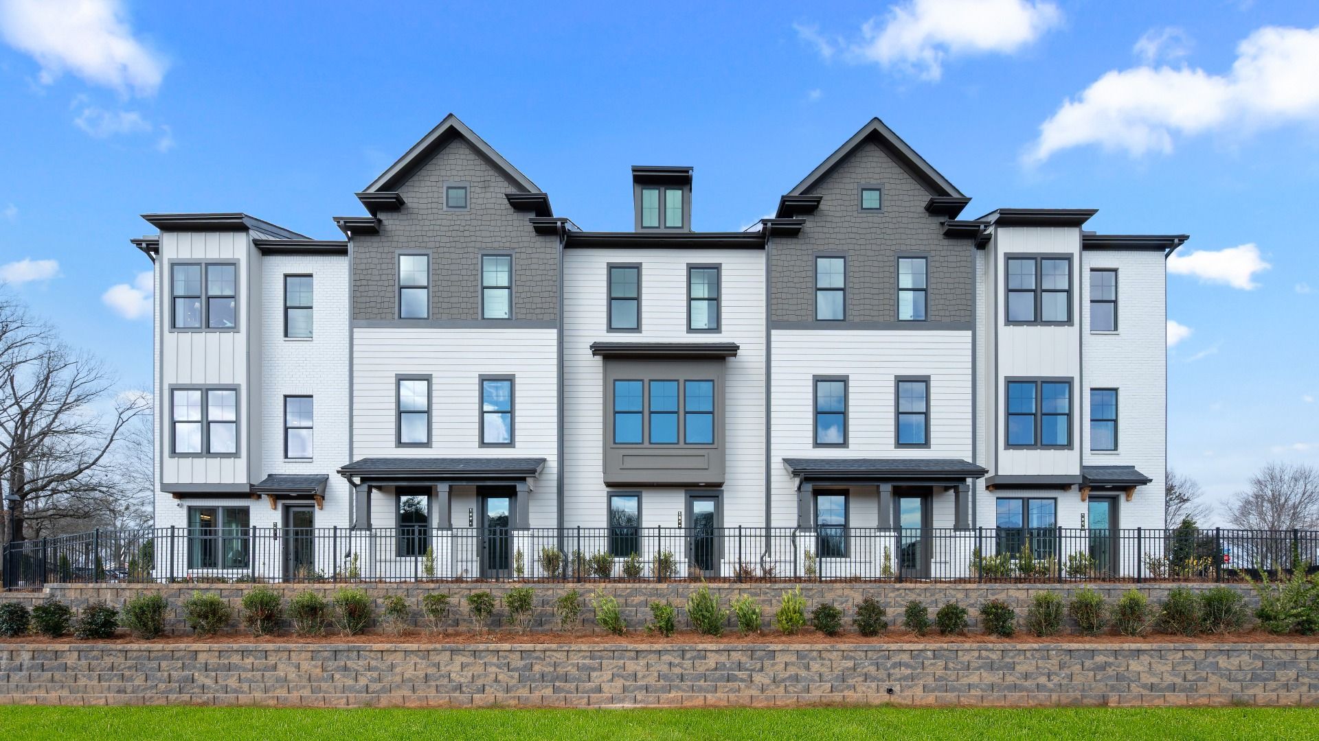 Three-story Barrett Pointe Seaton townhomes featuring contemporary design and landscaped grounds in Kennesaw, GA.
