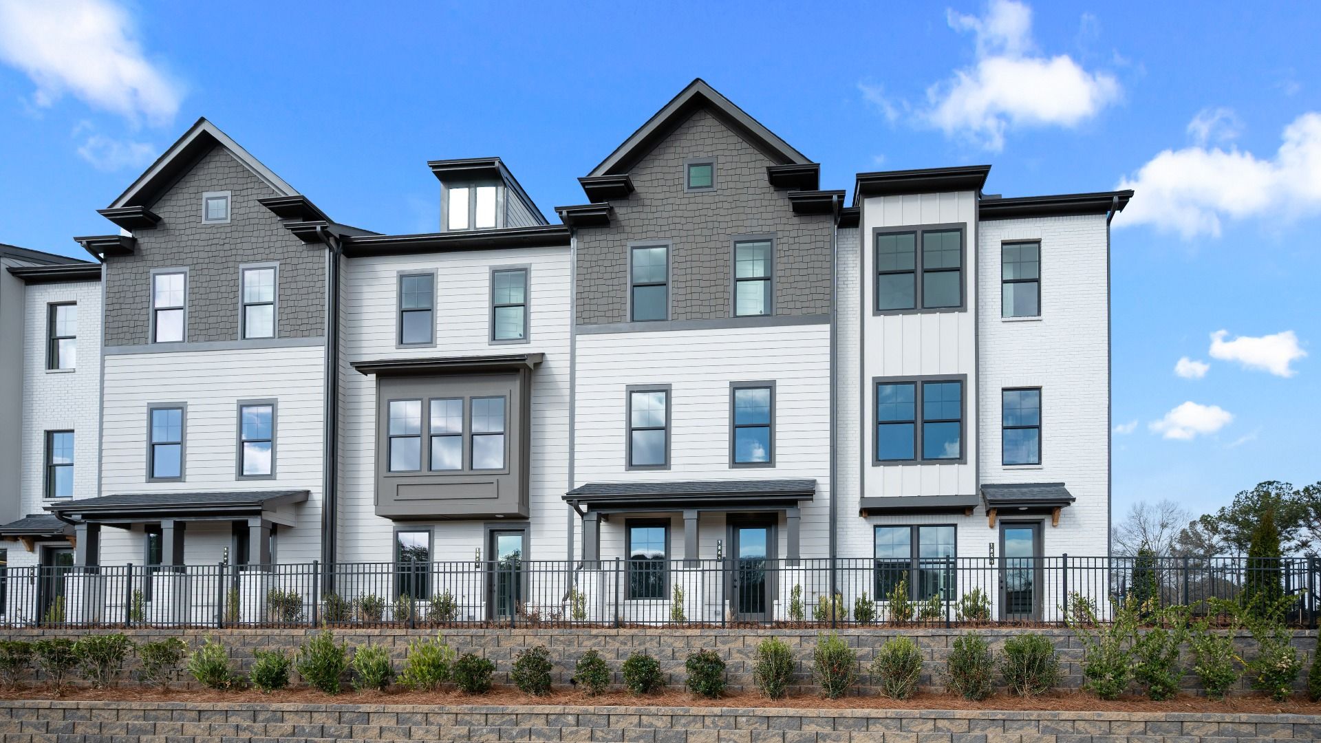 Three-story Barrett Pointe Seaton townhomes featuring contemporary design and landscaped grounds in Kennesaw, GA.