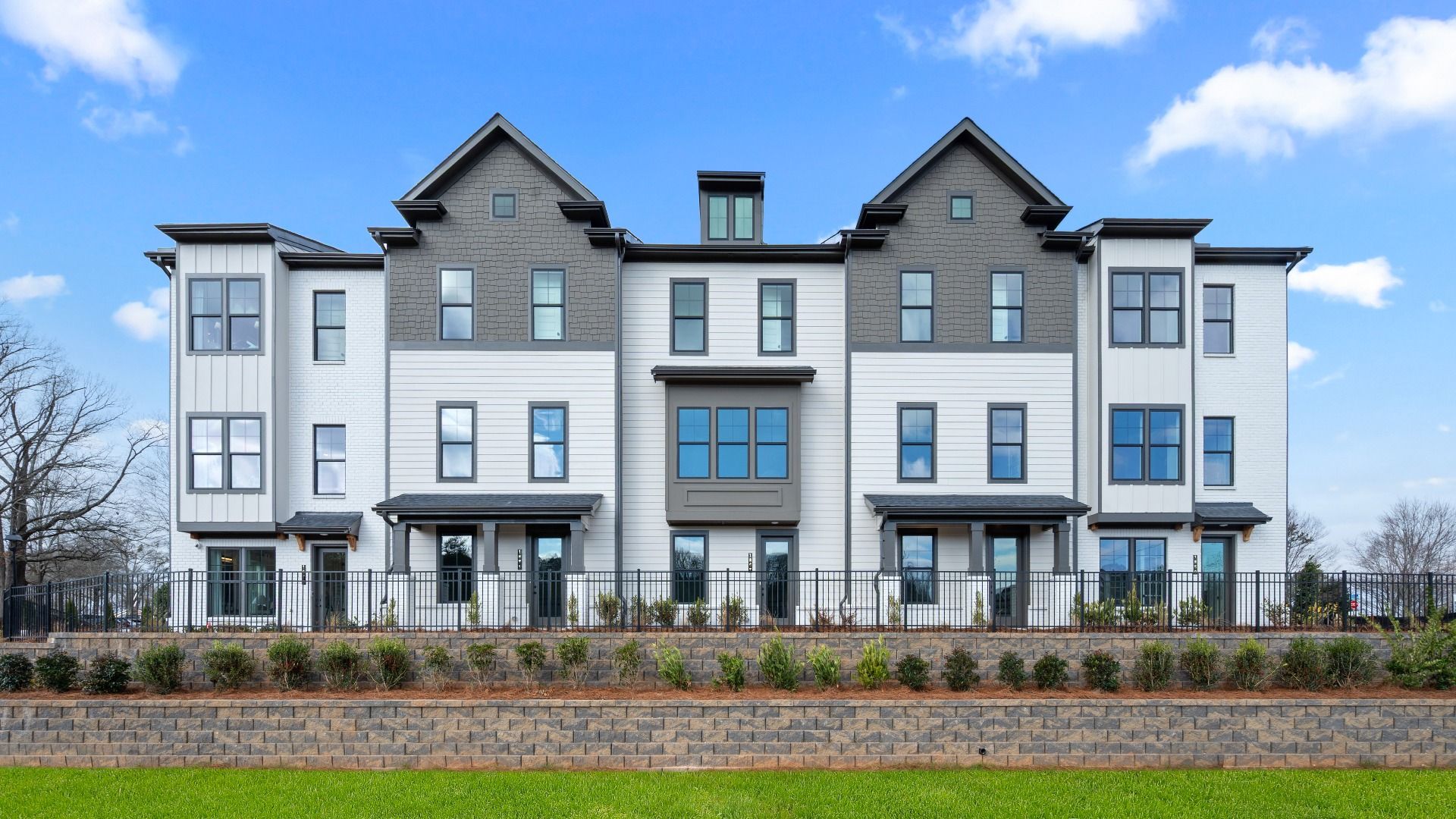 Three-story Barrett Pointe townhomes featuring contemporary design and landscaped grounds in Kennesaw, GA.
