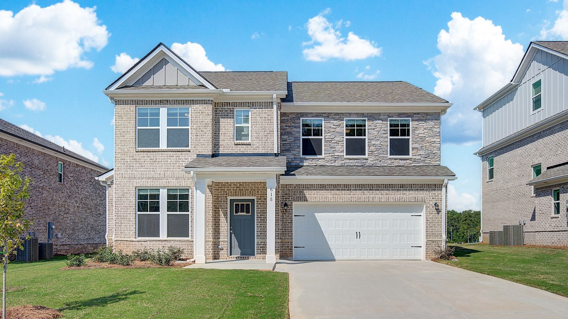 Ridgewood two-story brick home with stone accent and two-car front-entry garage at Bowers Farm in McDonough, GA.