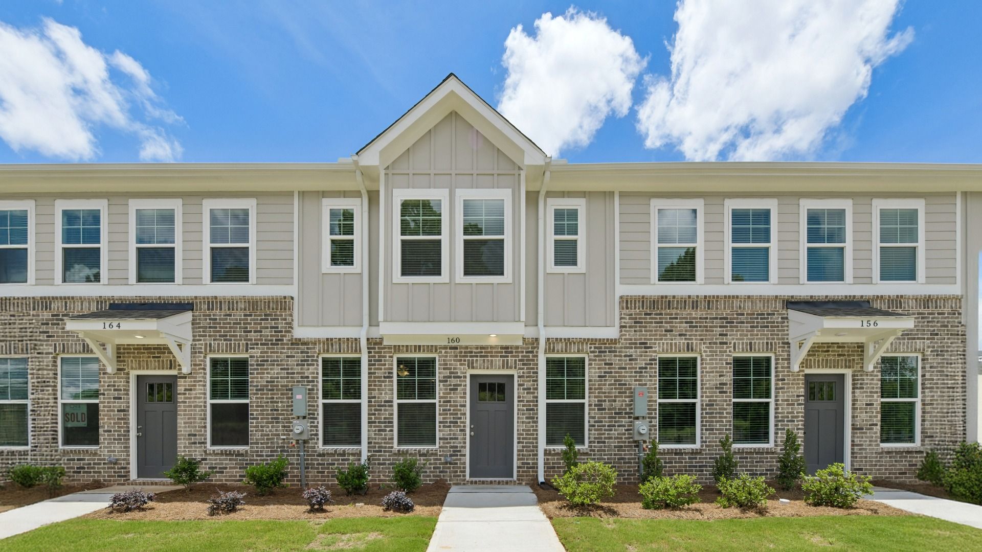 Mitchell two-story new construction townhome with brick and siding exterior and landscaped entryway at Avery Landing.