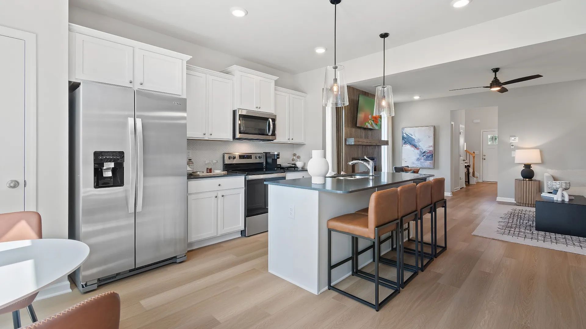 Bright kitchen with center island, modern backsplash, and seamless connection to living area at Westminster in Covington, GA.