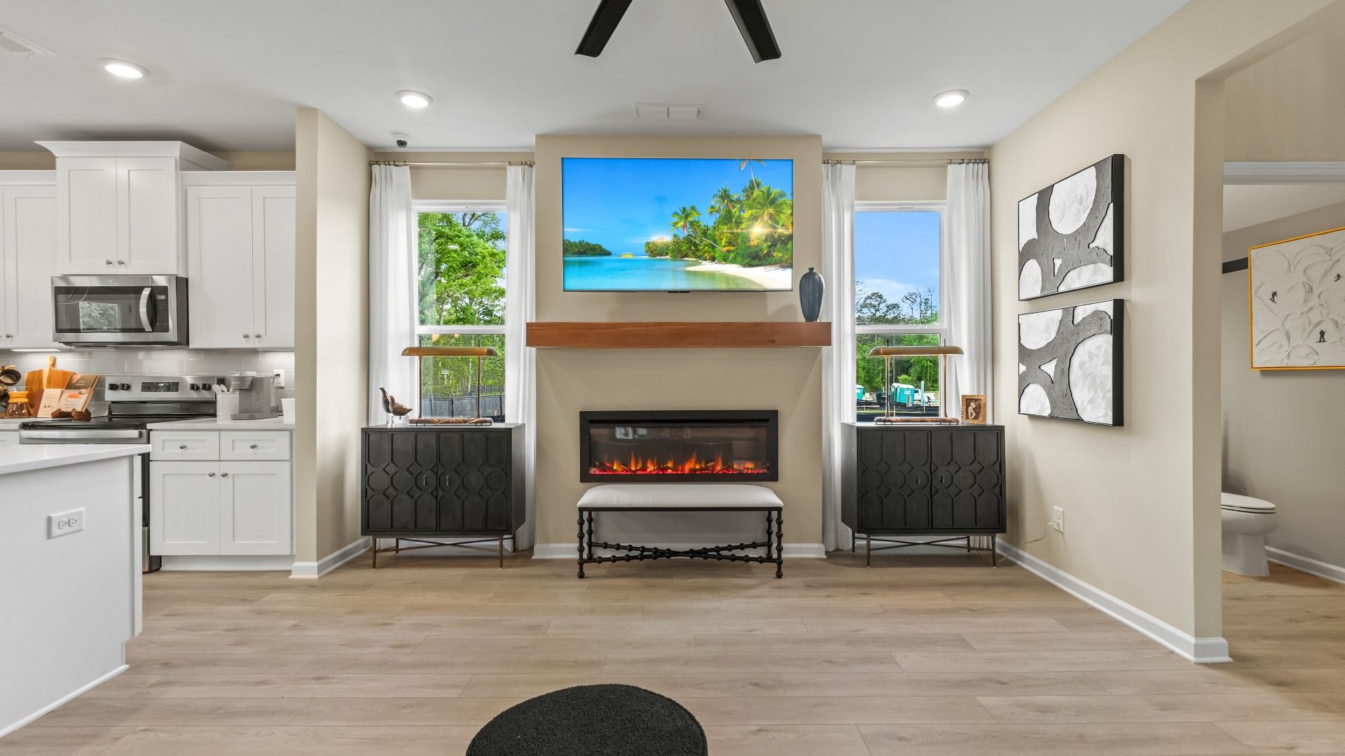 Bright family room featuring electric fireplace and natural light from oversized windows in Fairburn, GA.